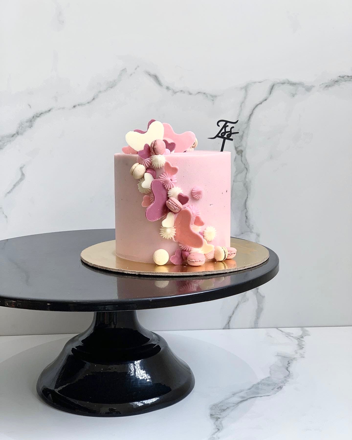 Valentine's Day cakes from The Sinful Spoon, decorated with hearts and romantic themes on a festive display.