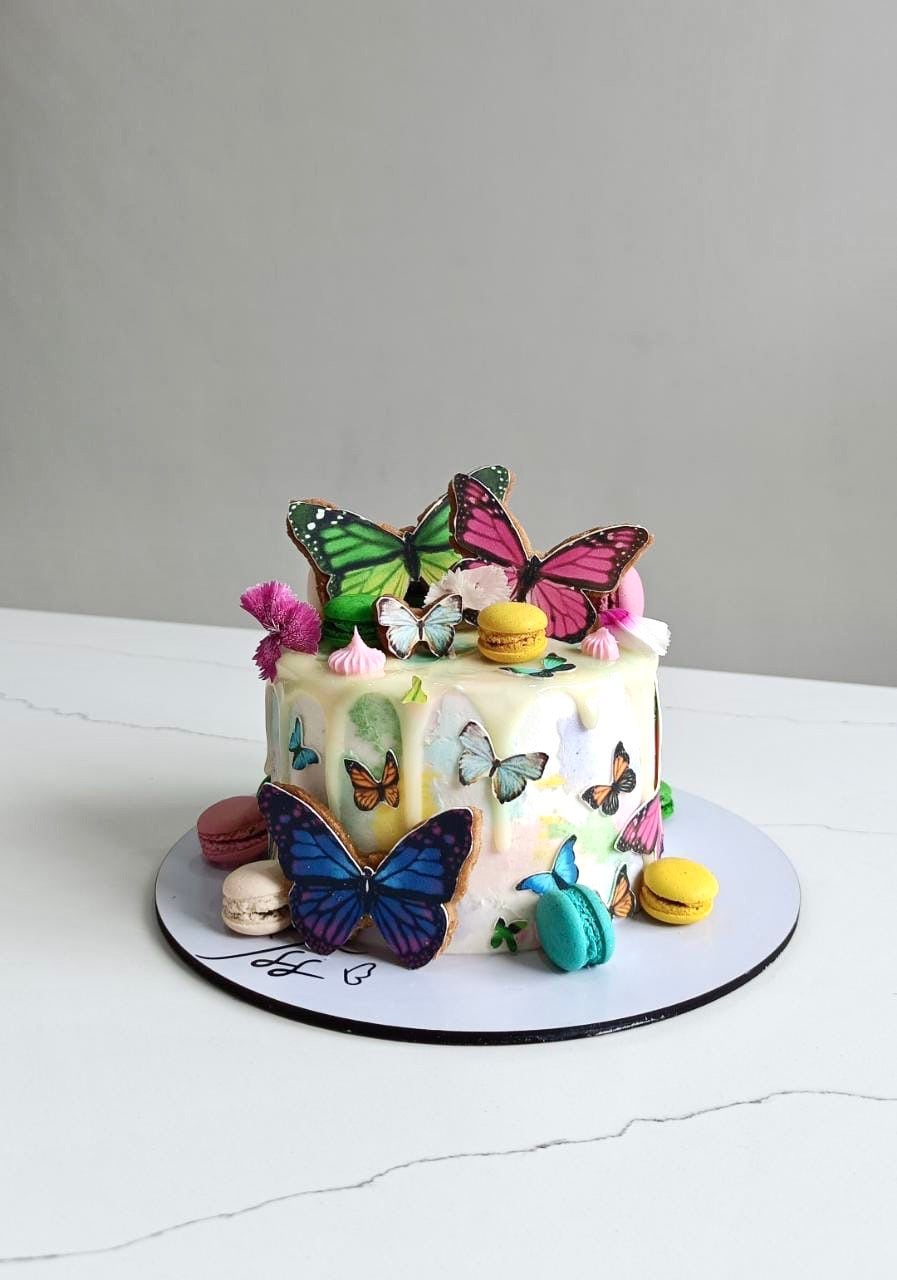 Edible paper cake decorated for a baby girl celebration with pastel colors and floral accents, by The Sinful Spoon.