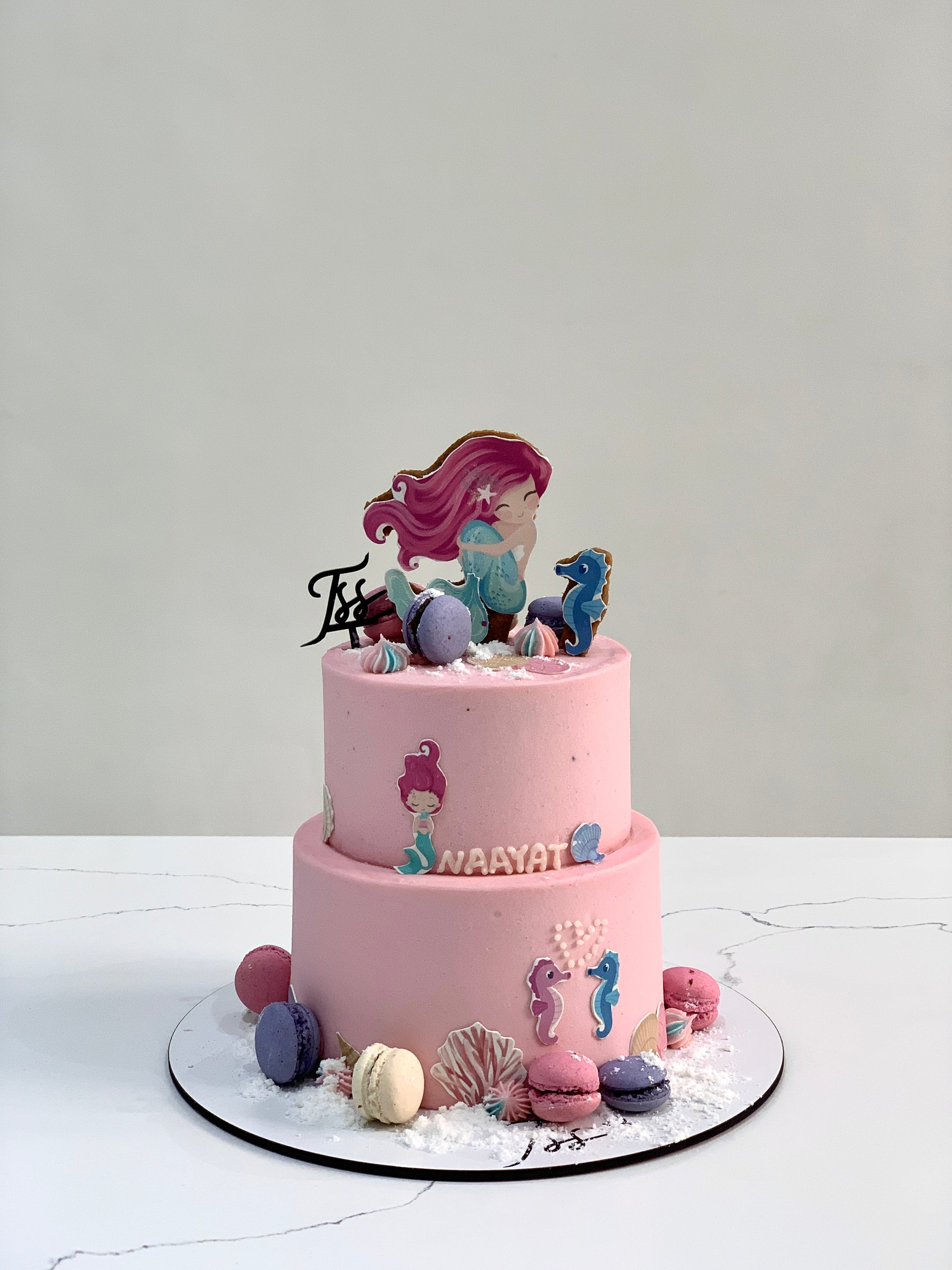 Miniature tier cakes from The Sinful Spoon, featuring layered frosting and decorative toppings, perfect for special occasions.