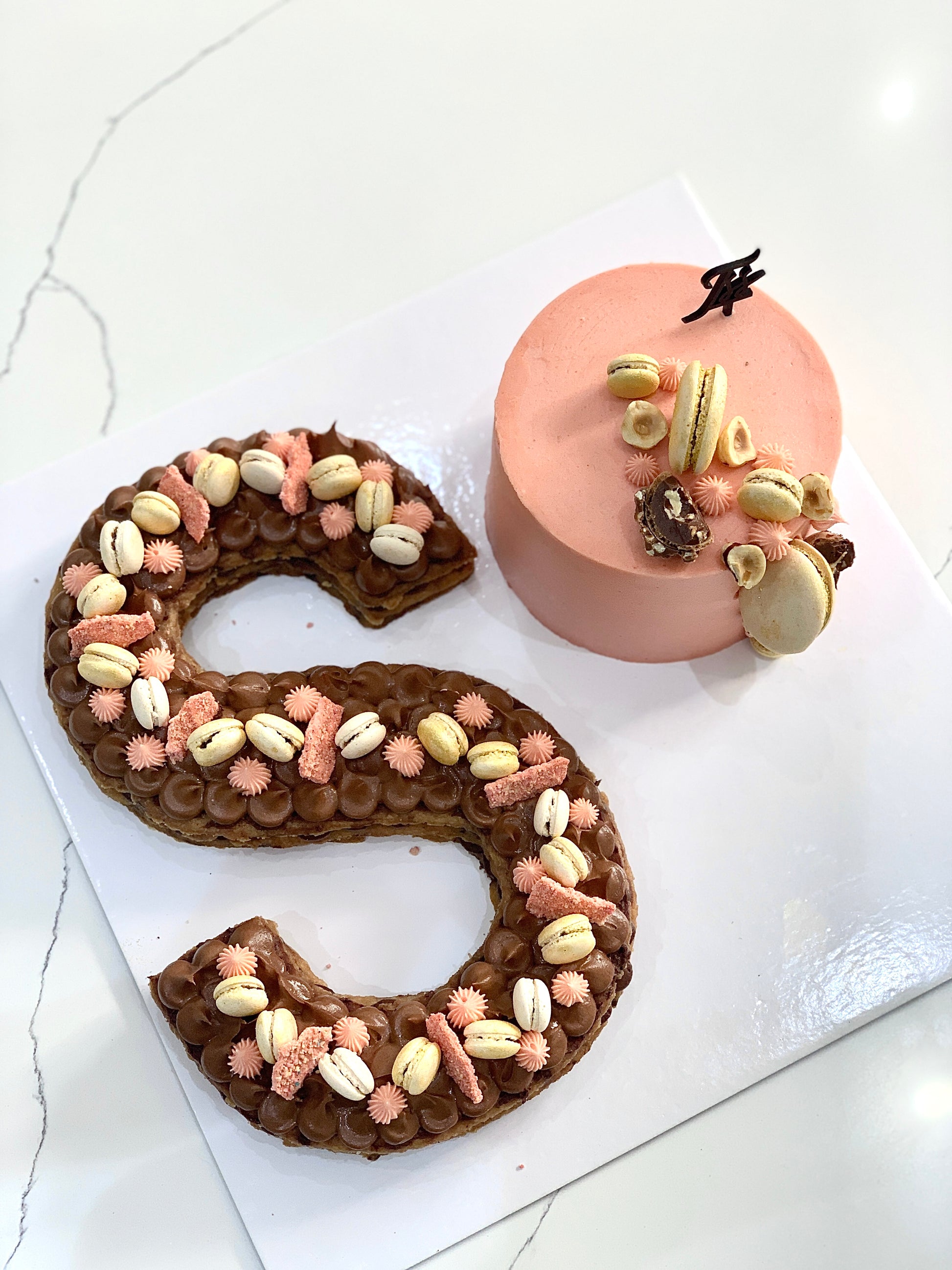 Assorted combo cakes from The Sinful Spoon displayed on a plate with colorful frosting and decorative toppings.