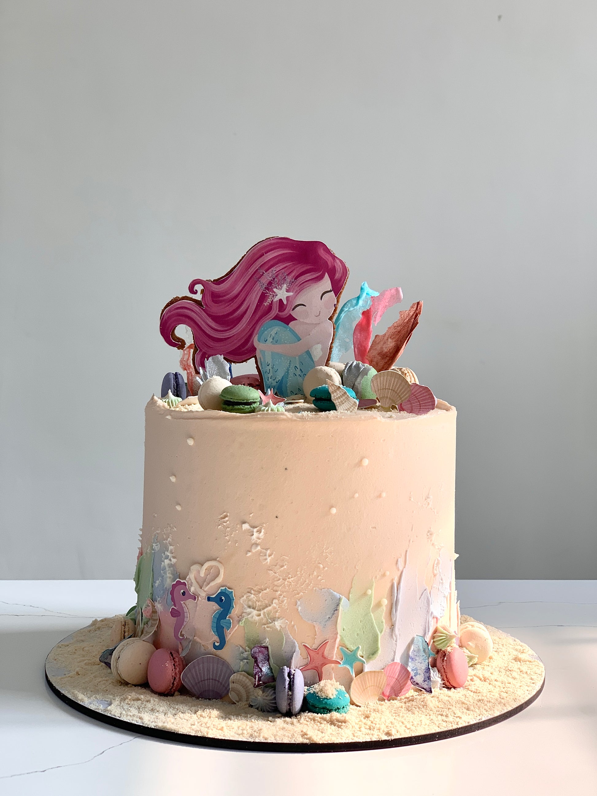 Edible paper cake featuring a baby girl design by The Sinful Spoon, decorated with colorful icing and intricate cake details.