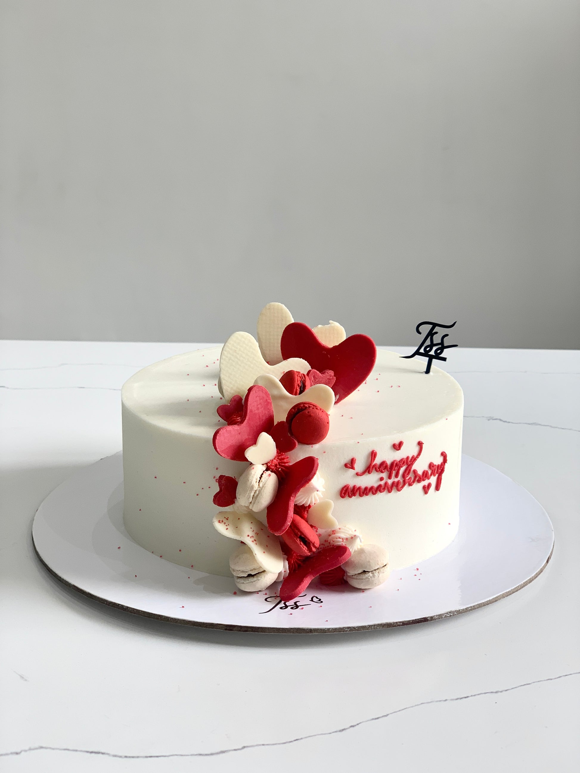 Decorative Valentine's Day cake from The Sinful Spoon with pink and red frosting, heart-shaped decorations, and festive design.