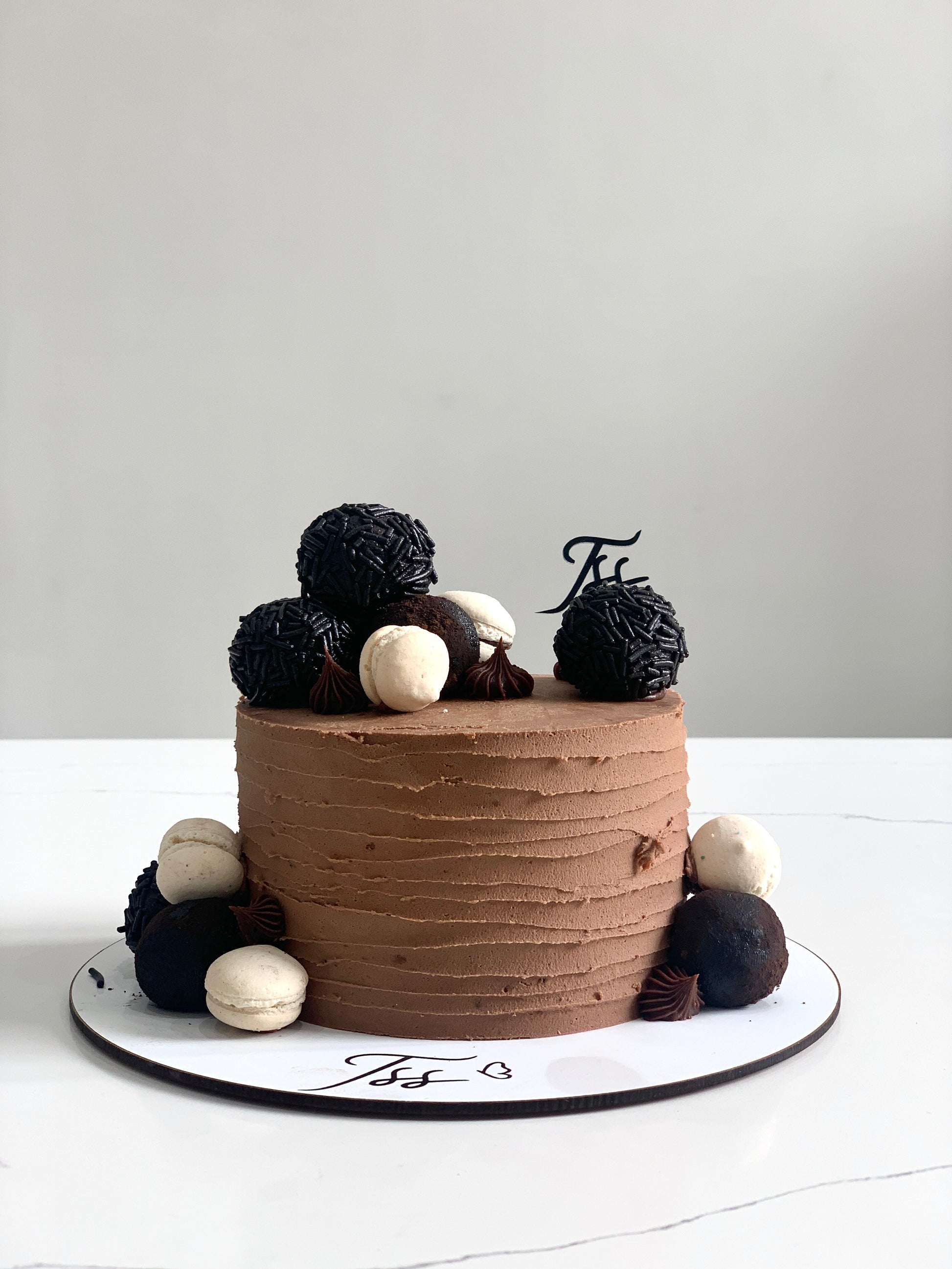 Slice of classic cake from The Sinful Spoon with creamy frosting and layered texture, displayed on a white plate.
