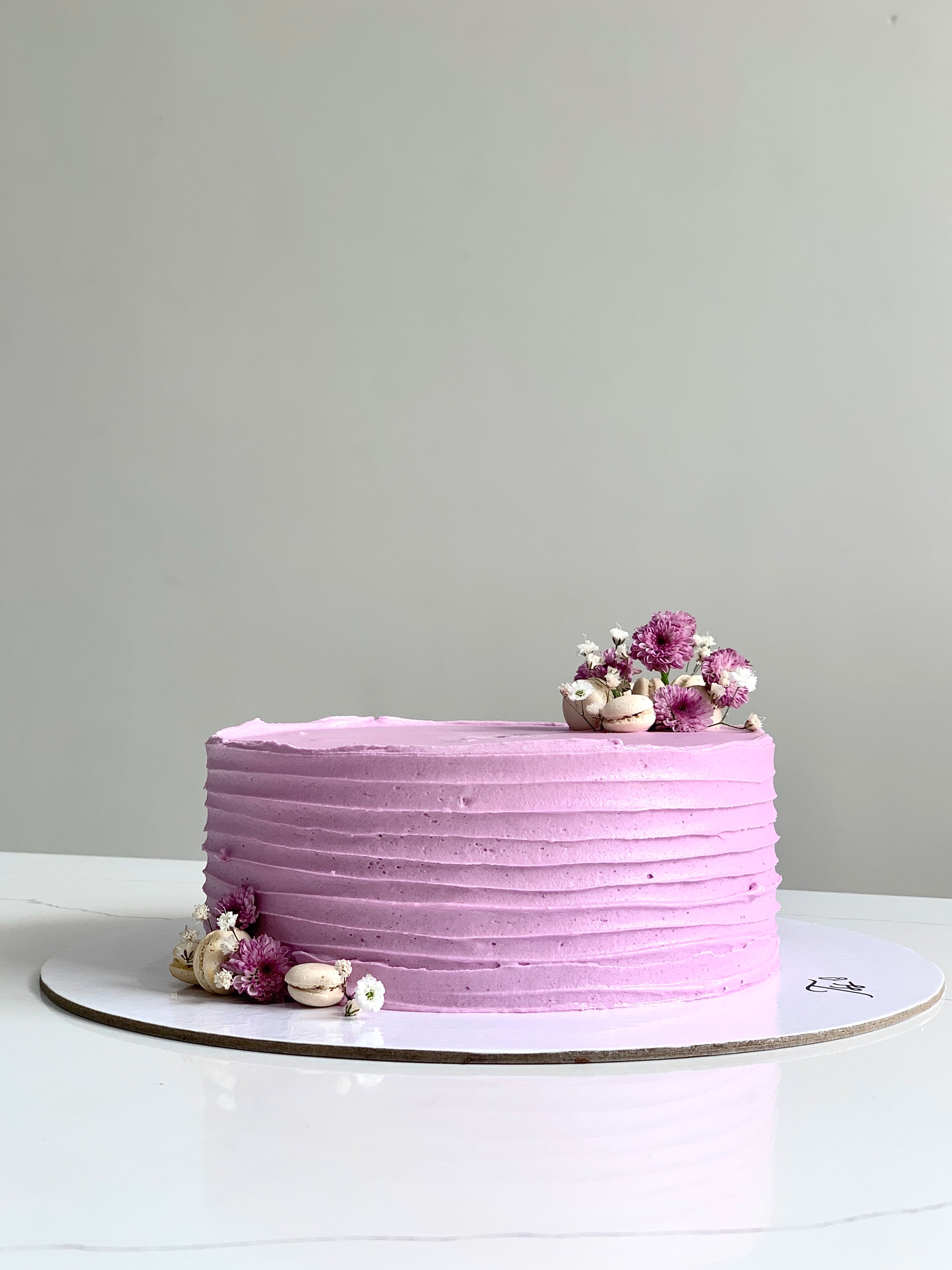 A classic cake from The Sinful Spoon with creamy frosting and layered sponge, displayed on a plate for serving.