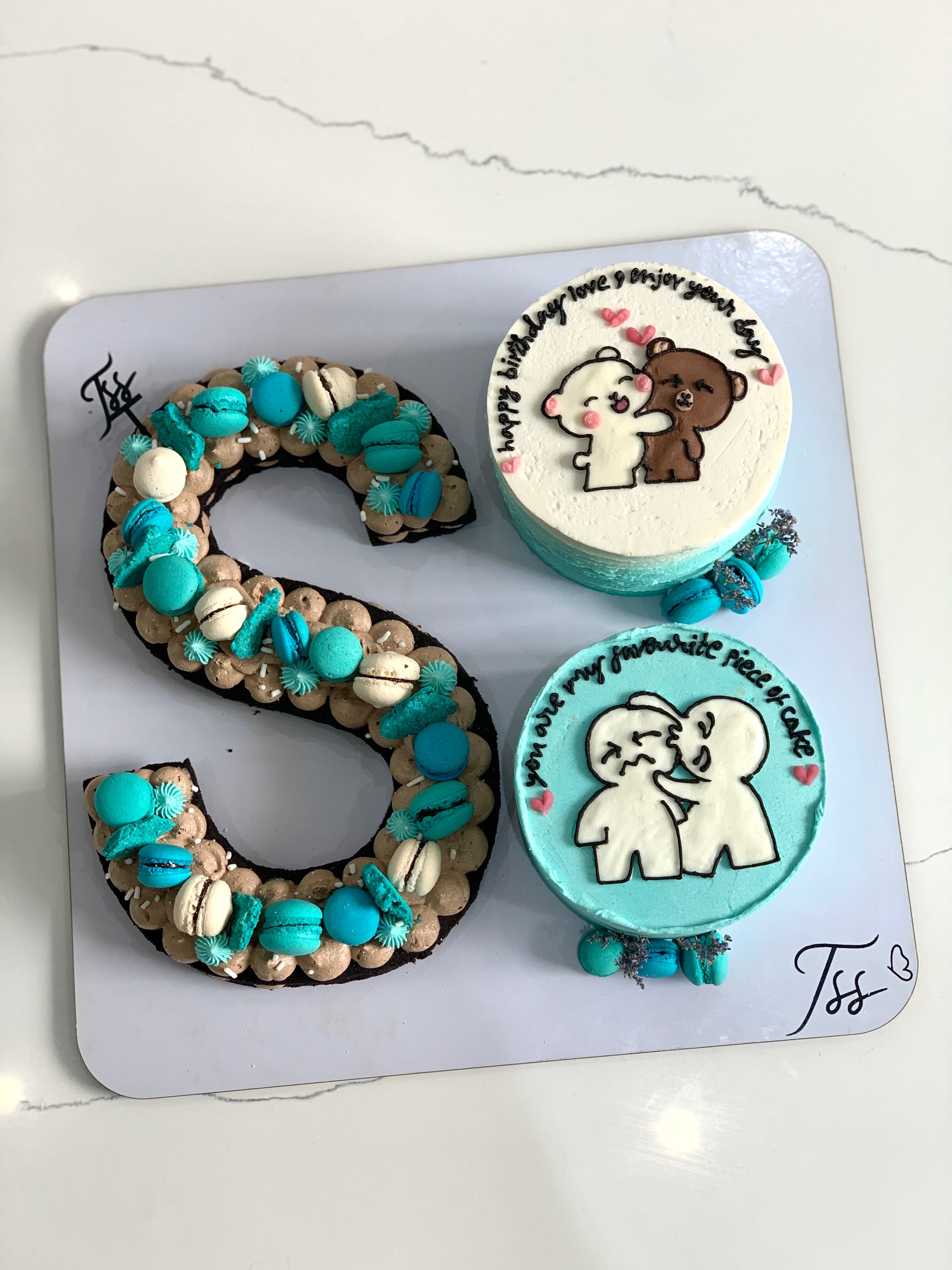 Assorted combo cakes from The Sinful Spoon with colorful frosting and decorative toppings on a white plate.