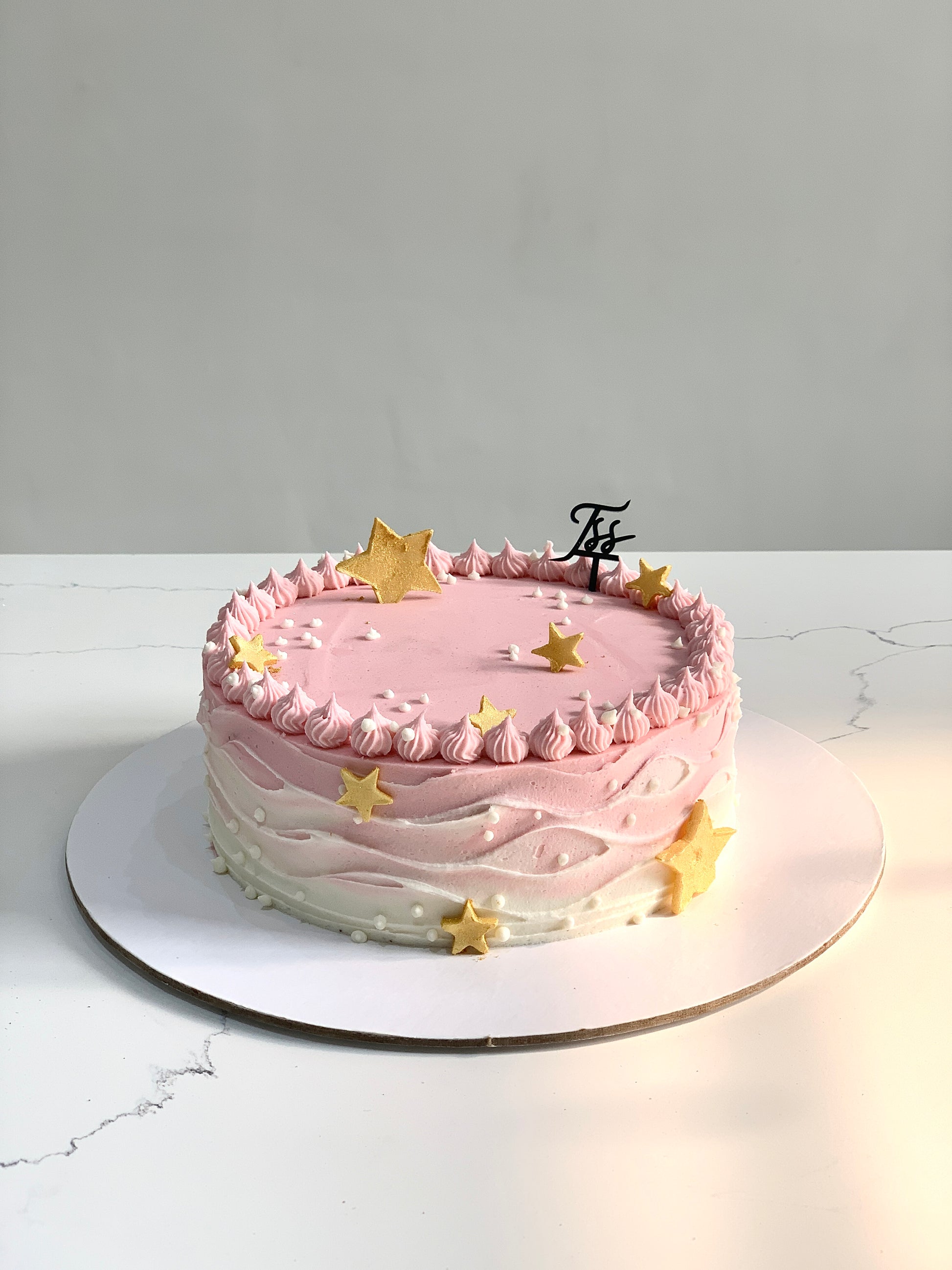 Colorful bento cake from The Sinful Spoon with layered frosting and decorative toppings, displayed on a white plate.