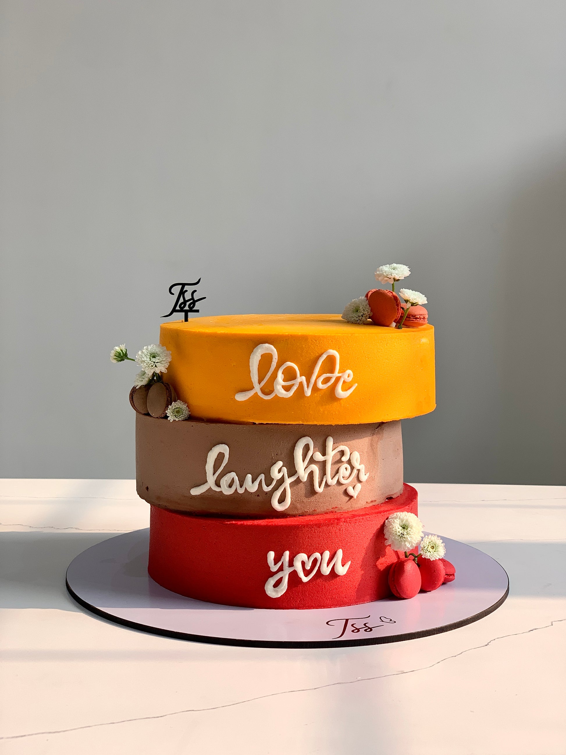 Asymmetrical chocolate cake from The Sinful Spoon with layered frosting and artistic design, displayed on a white plate.