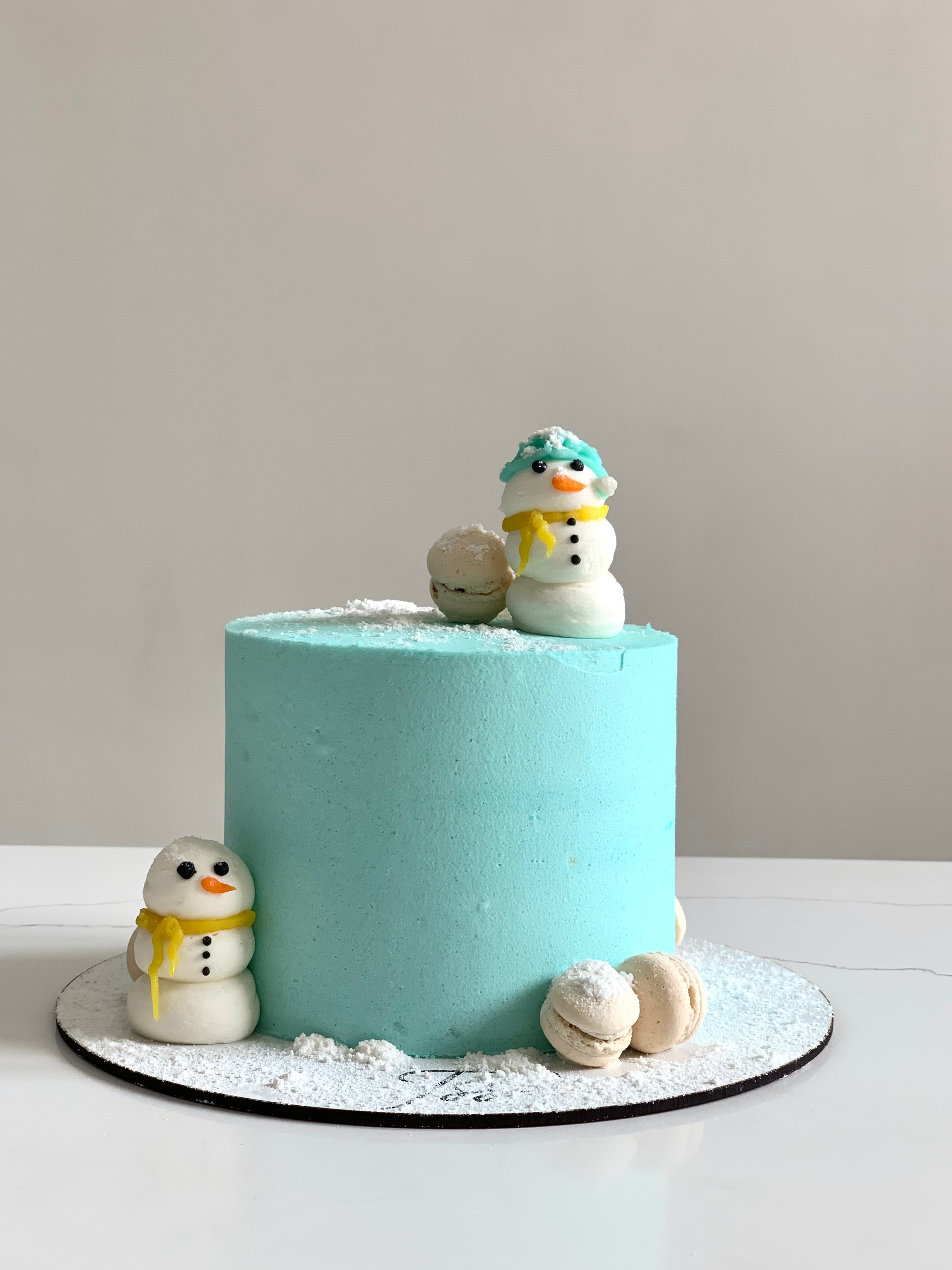 Decorative Christmas cakes from The Sinful Spoon with festive icing and holiday-themed designs on a white plate.