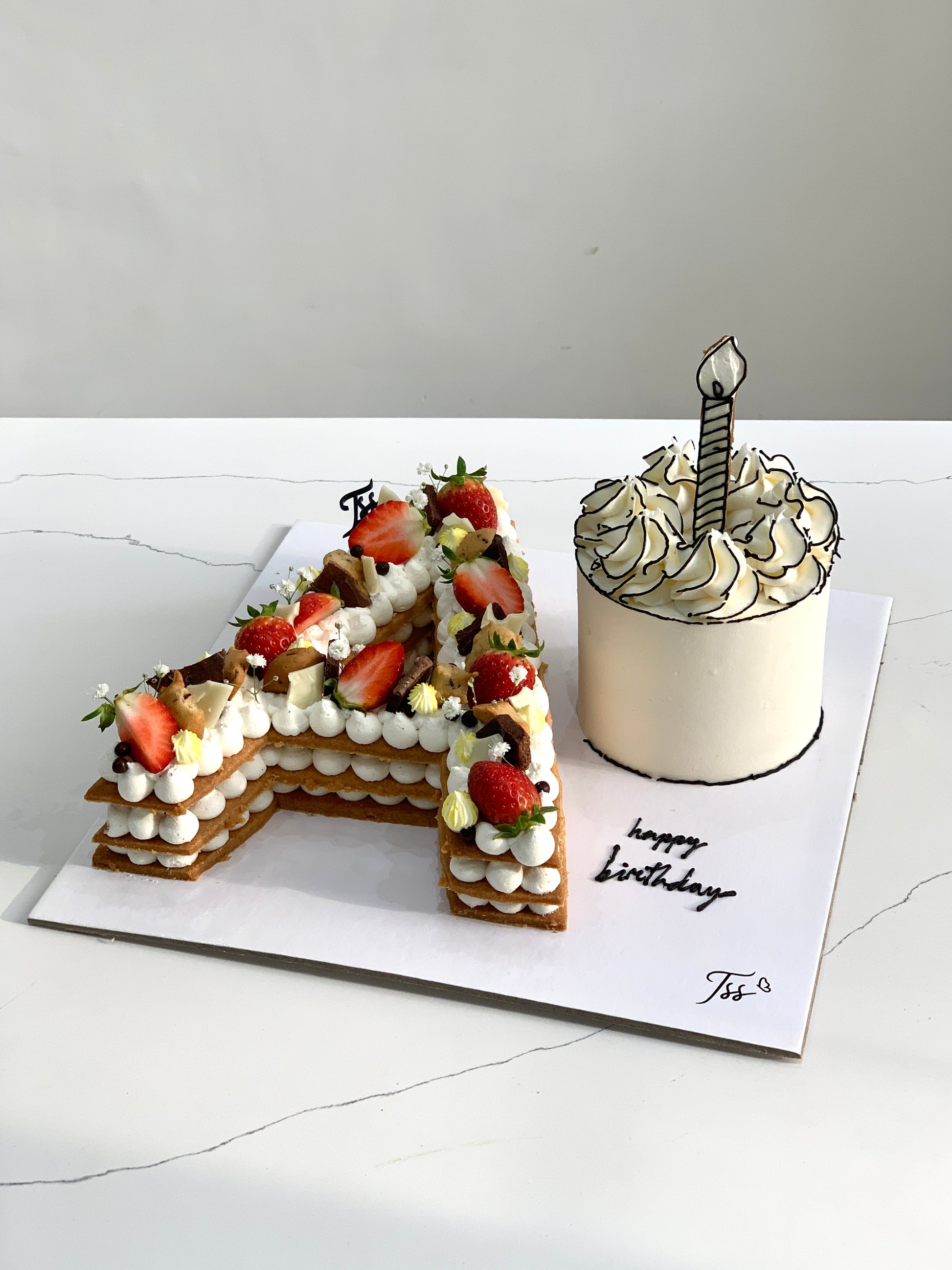 Assorted combo cakes from The Sinful Spoon with colorful frosting and decorative toppings, displayed on a platter.