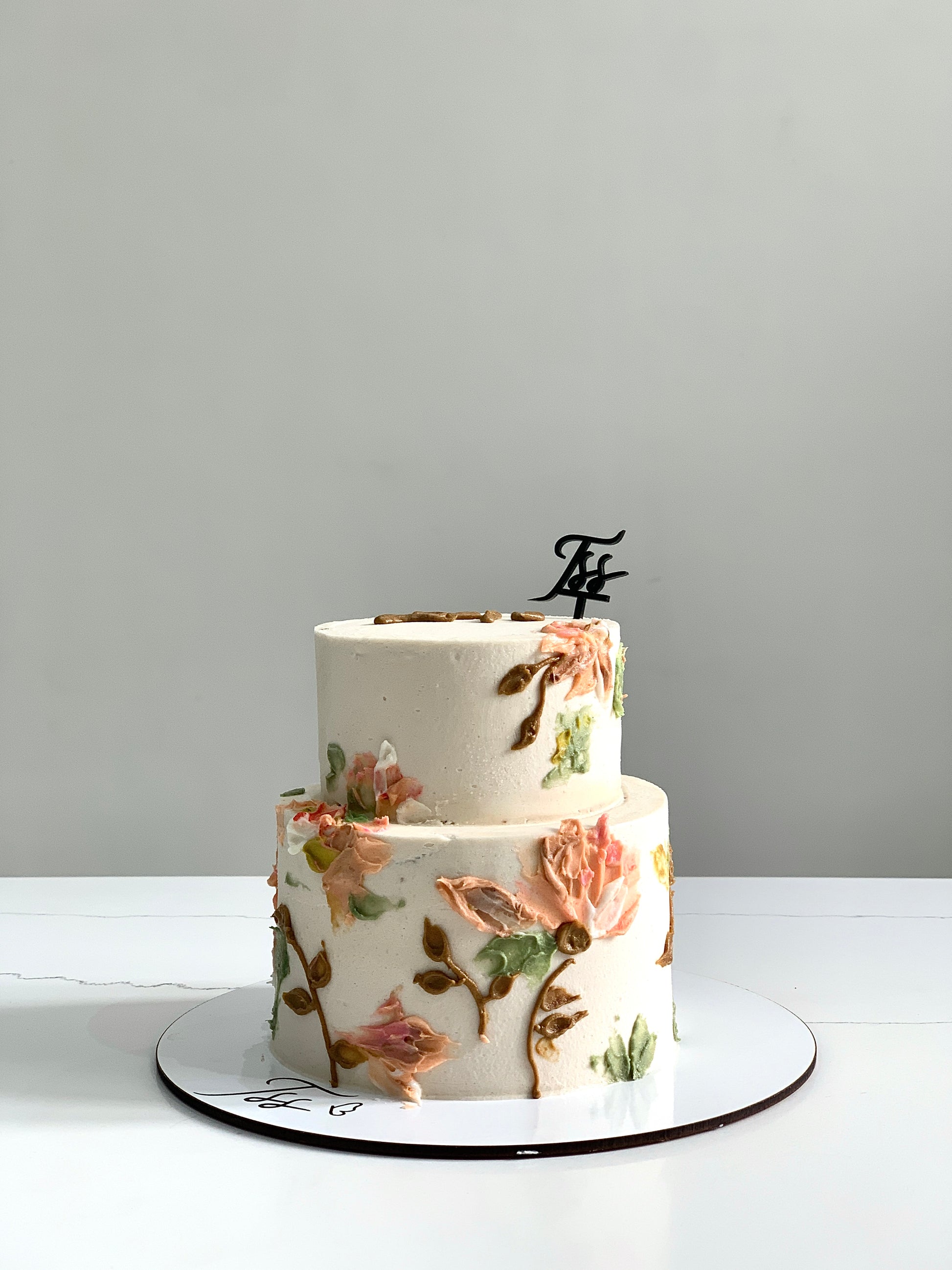 Miniature tier cakes from The Sinful Spoon with colorful frosting and decorative toppings, perfect for special occasions.
