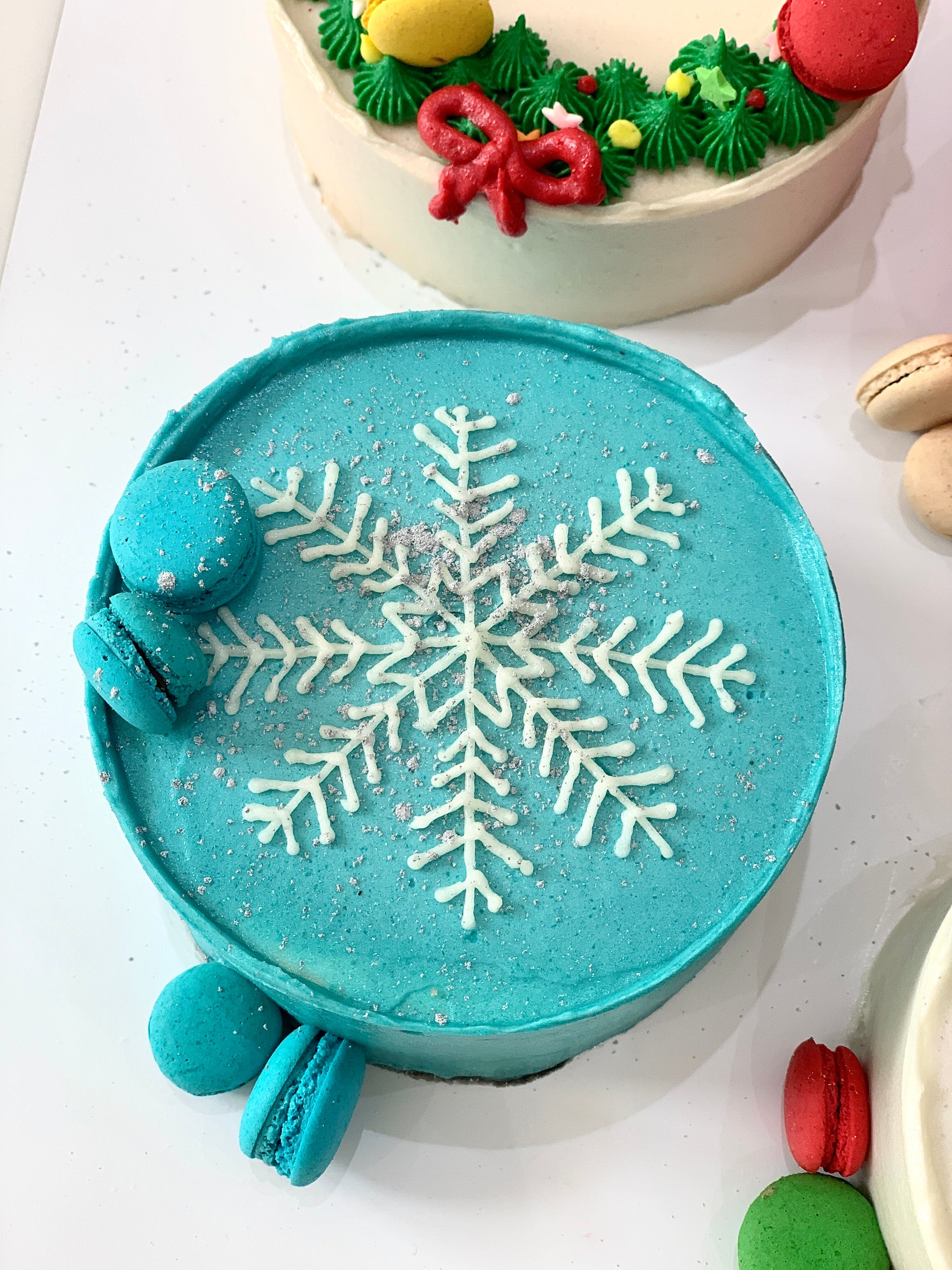 Decorative Christmas cake from The Sinful Spoon with festive icing and holiday-themed decorations on a white plate.