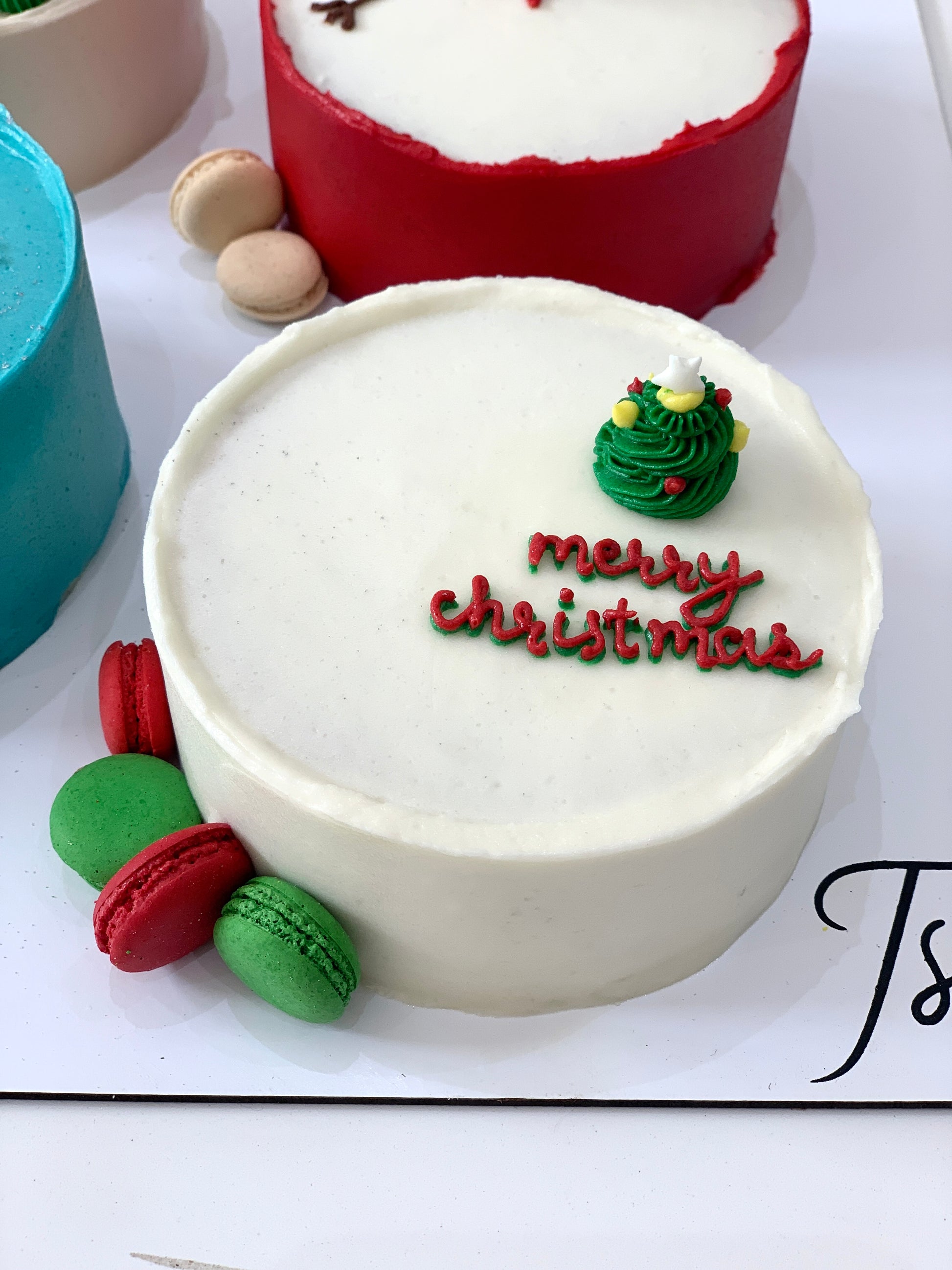 Decorative Christmas cakes from The Sinful Spoon with festive icing and holiday-themed decorations on a platter.