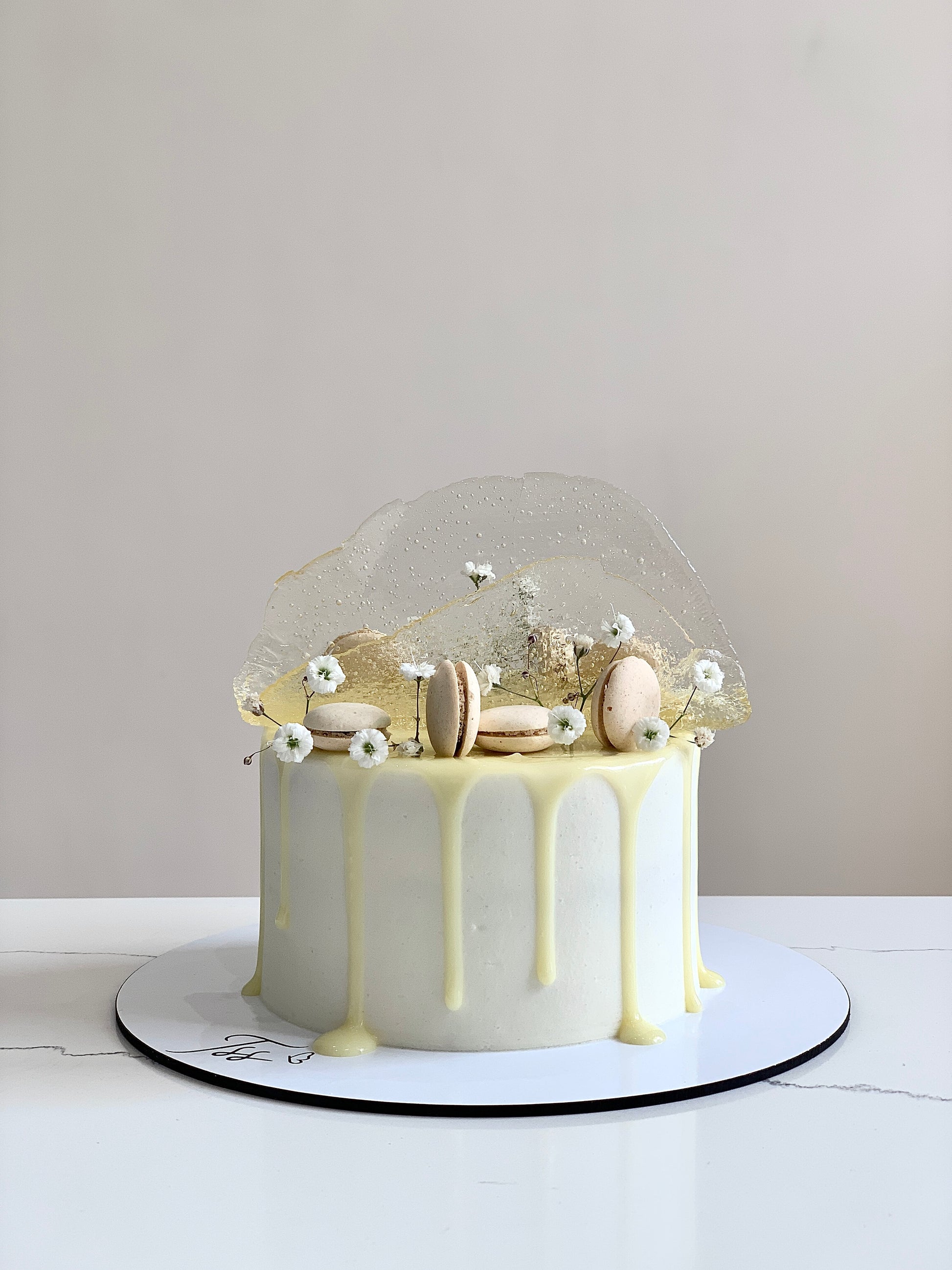 Colorful isomalt cakes from The Sinful Spoon, showcasing vibrant, glossy sugar art pieces on a clean background.