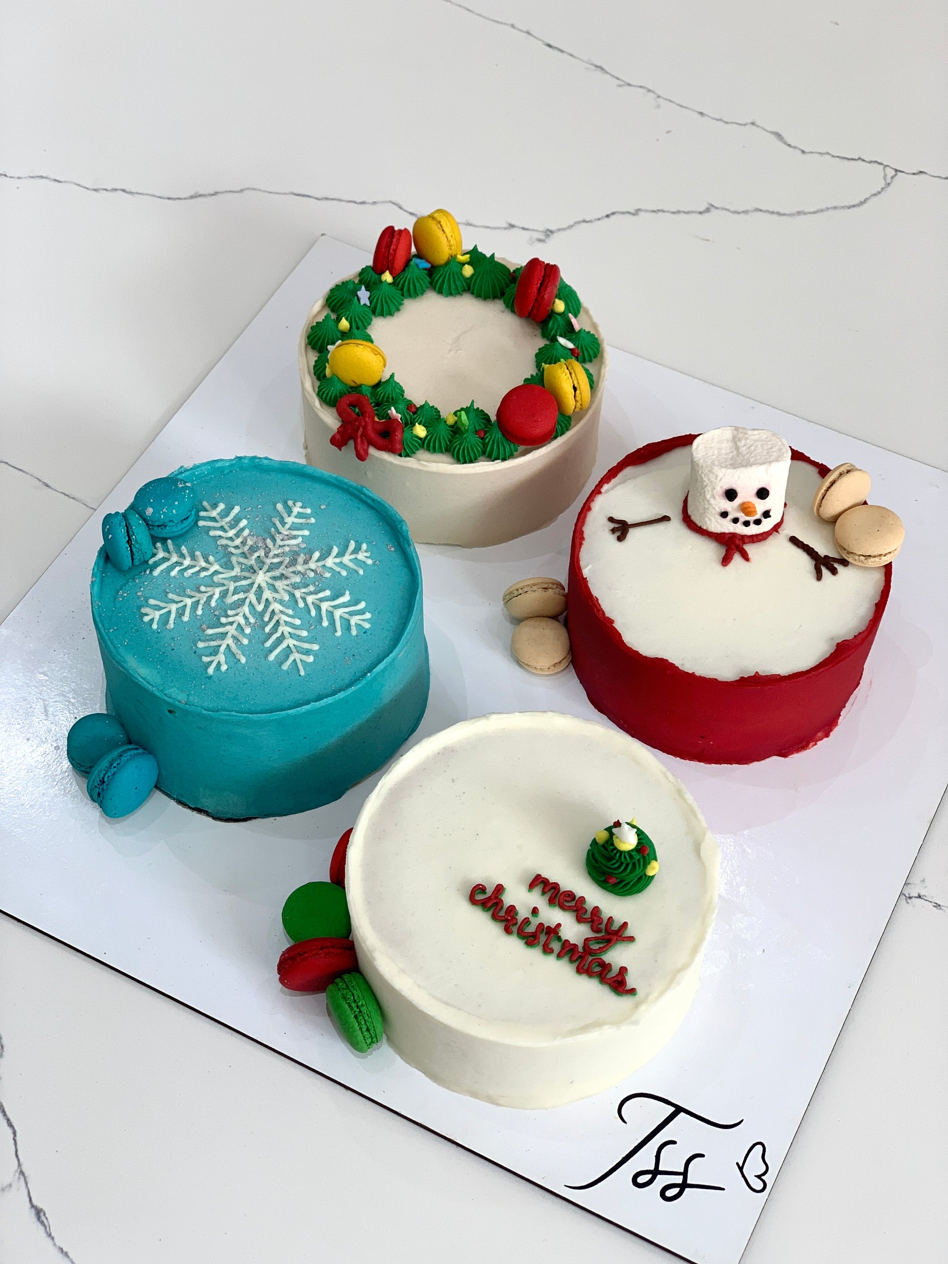 Decorative Christmas cakes from The Sinful Spoon, featuring festive icing and holiday-themed designs.