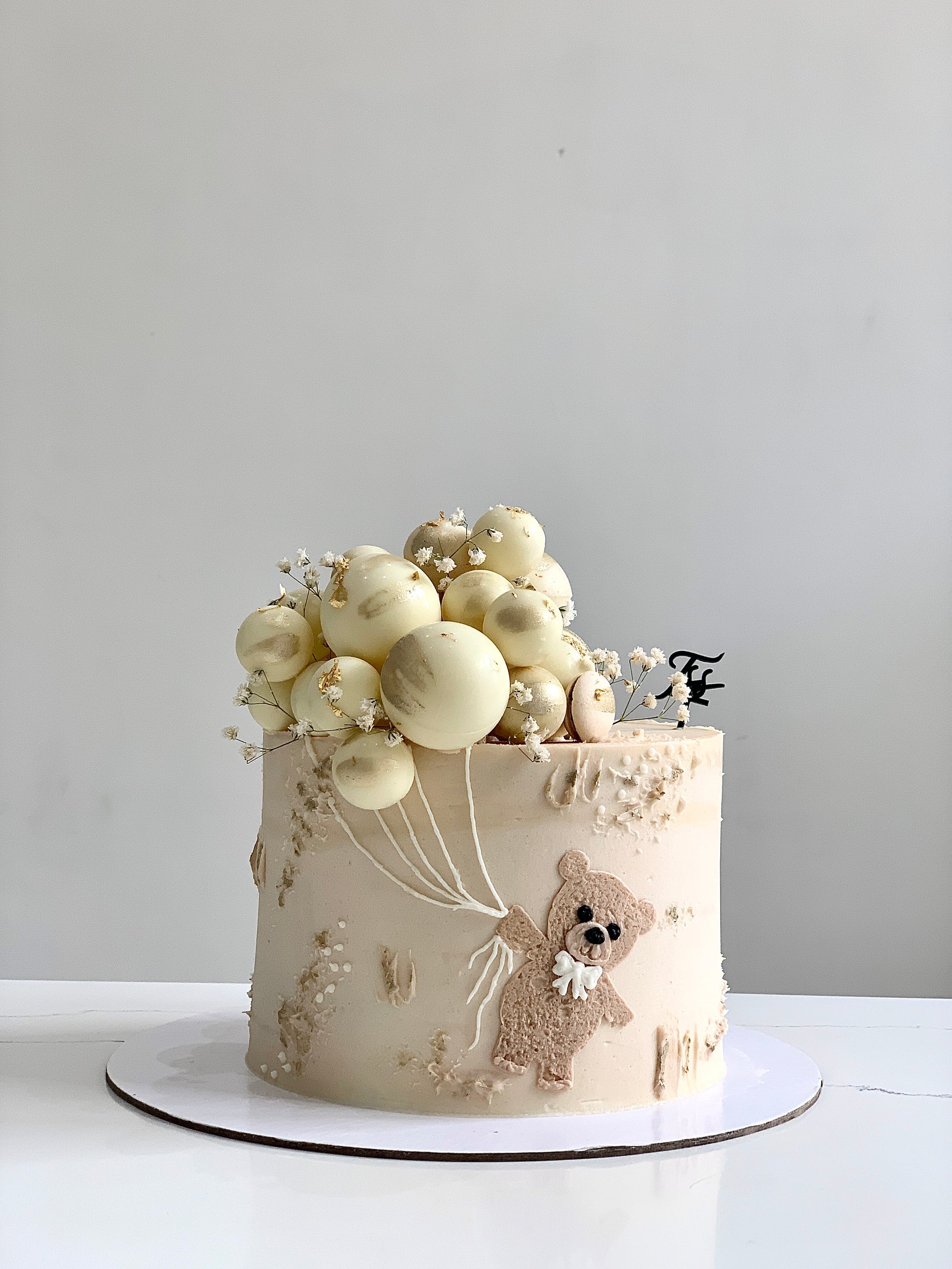 Decorative Baby Shower Cake from The Sinful Spoon featuring pastel colors, baby-themed decorations, and intricate icing details.