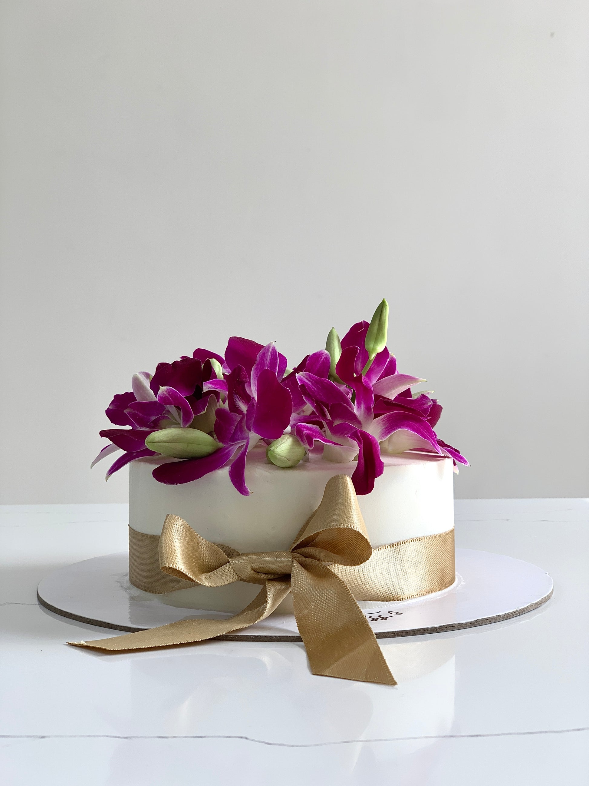 Fresh floral cake from The Sinful Spoon featuring colorful edible flowers and intricate decorative icing.