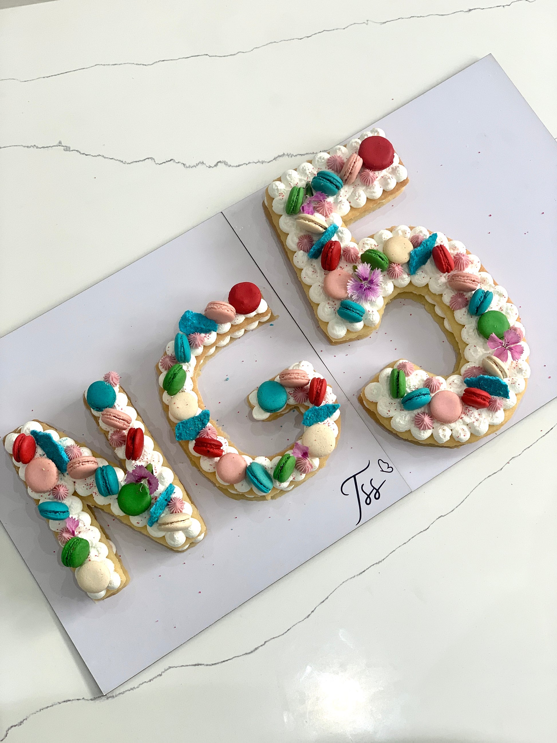 A slice of Cookie Cake from The Sinful Spoon with chocolate chips and colorful sprinkles on a white plate.