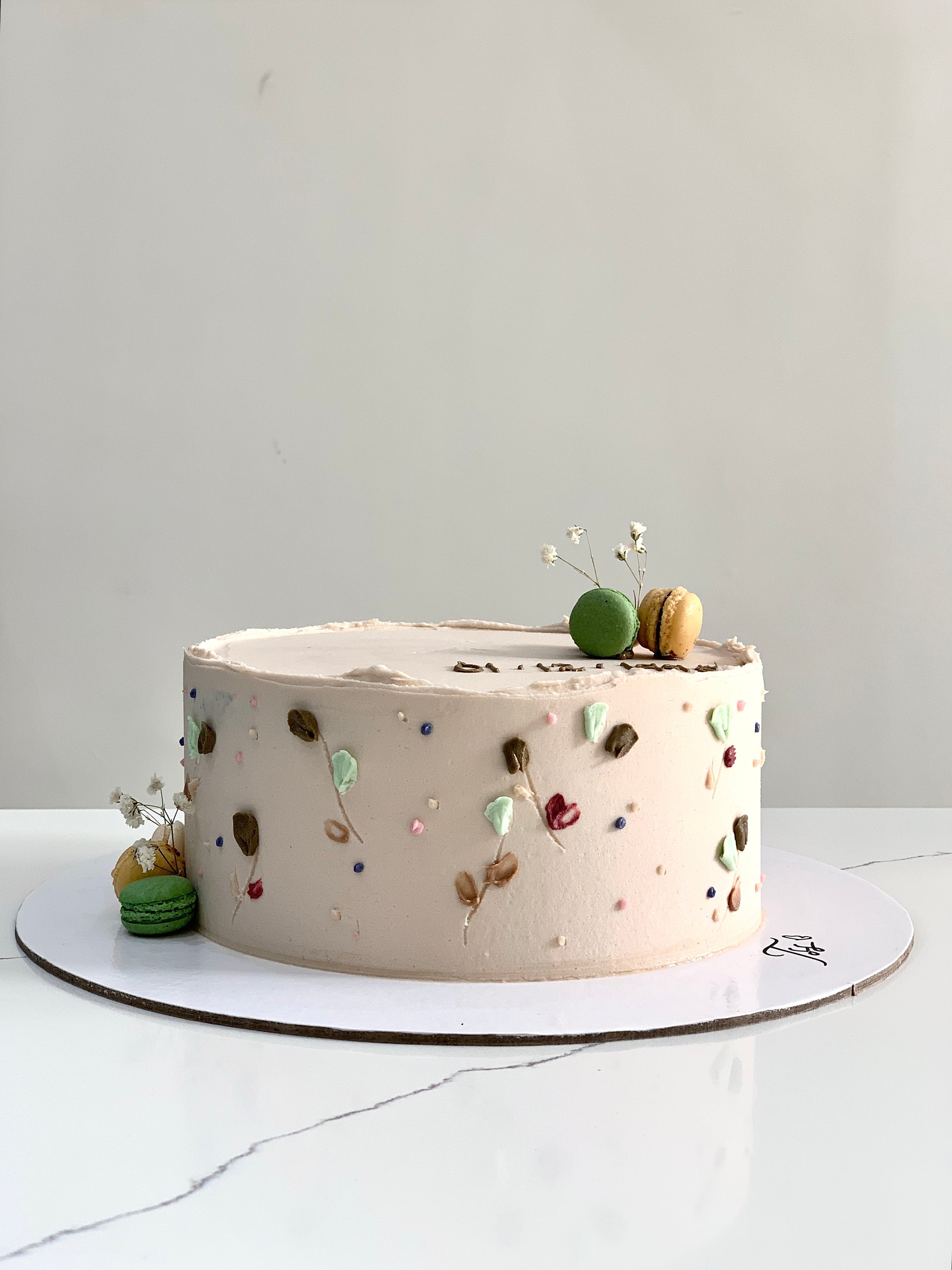 Decorative buttercream flower cake by The Sinful Spoon, featuring colorful floral piping and intricate frosting details.