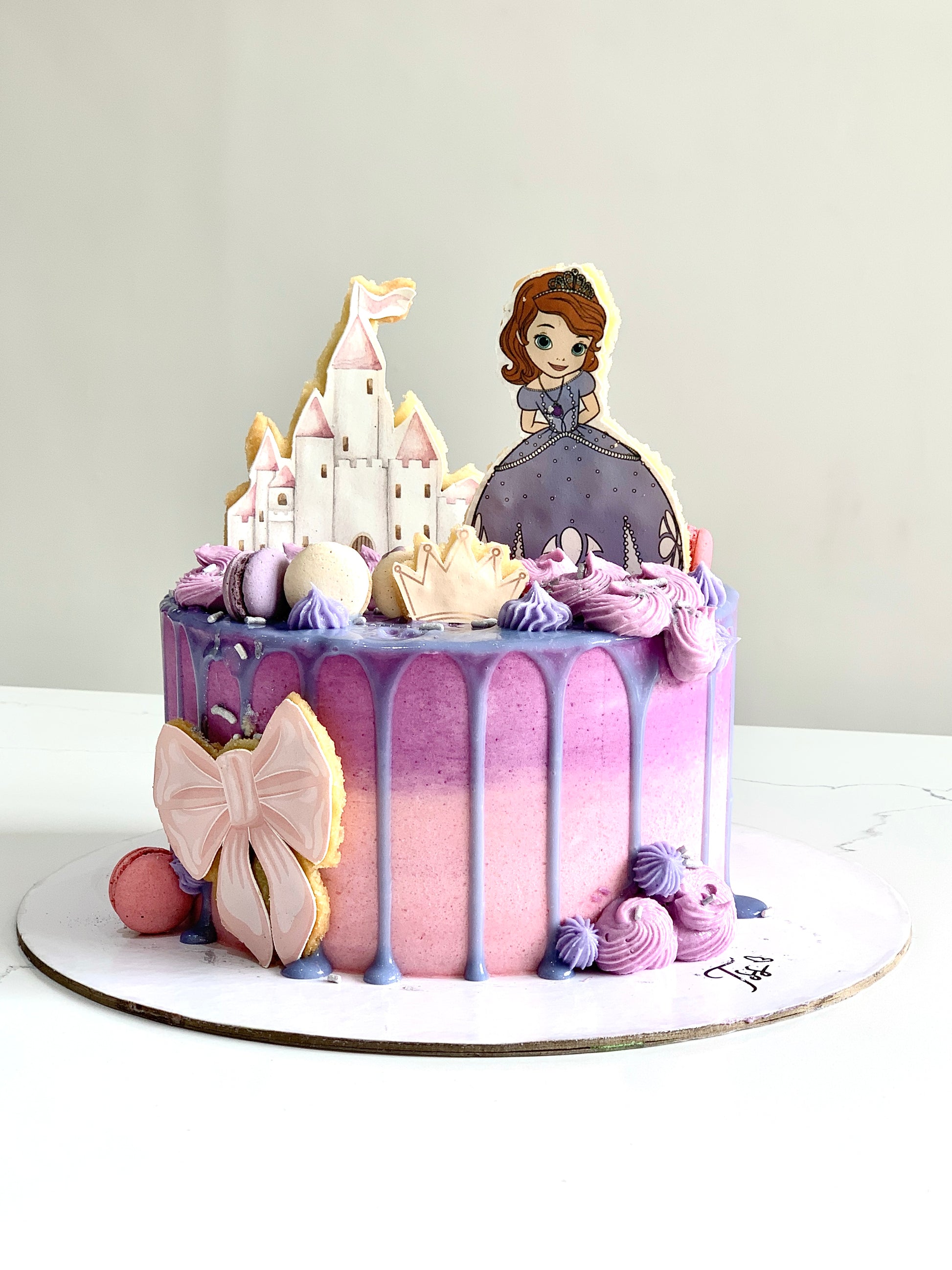 Edible paper cake for baby girl by The Sinful Spoon, decorated with pink and white icing and cute baby-themed designs.