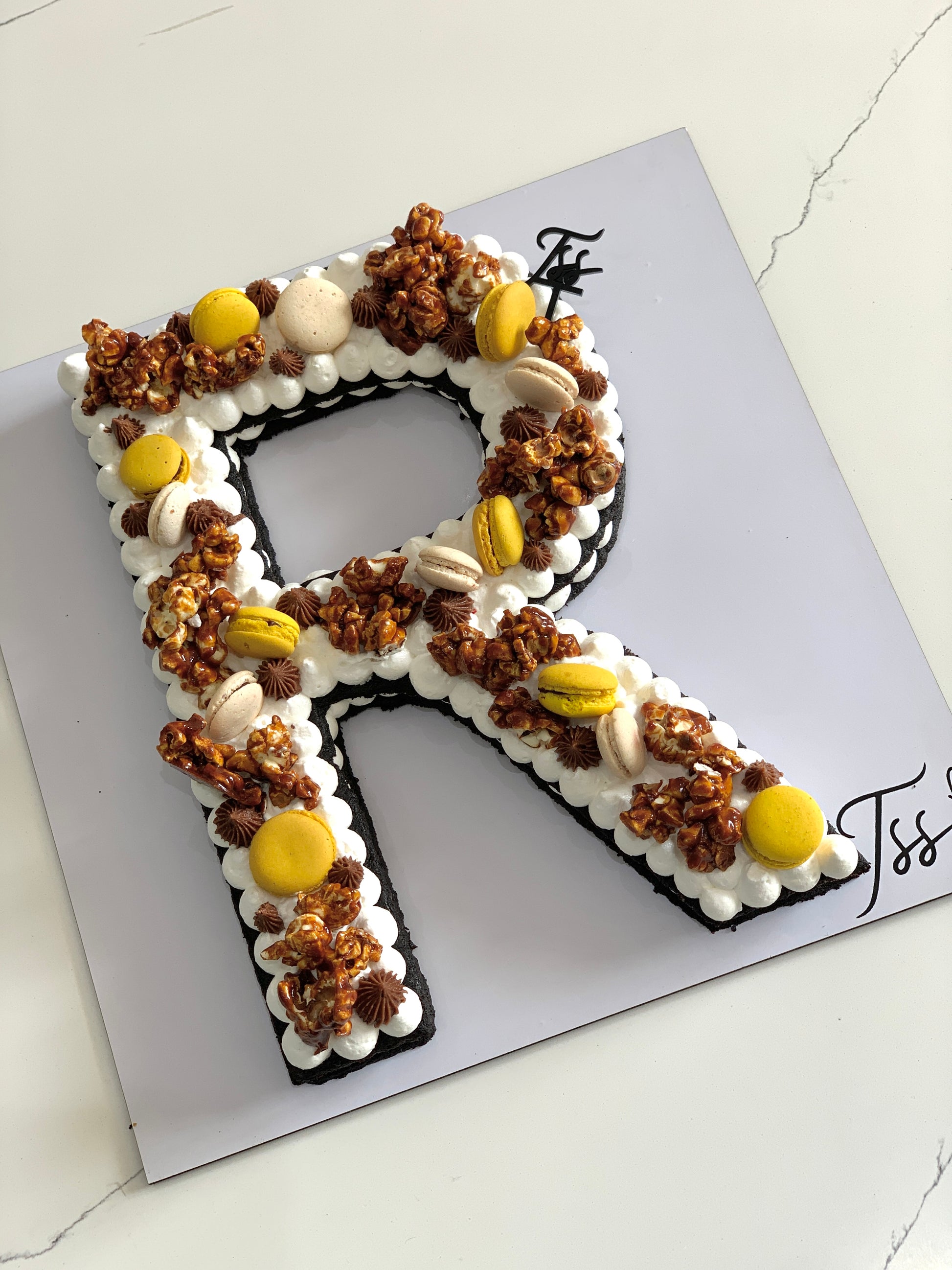 Chocolate cookie cake from The Sinful Spoon with colorful sprinkles and a layered, topped design on a white plate.
