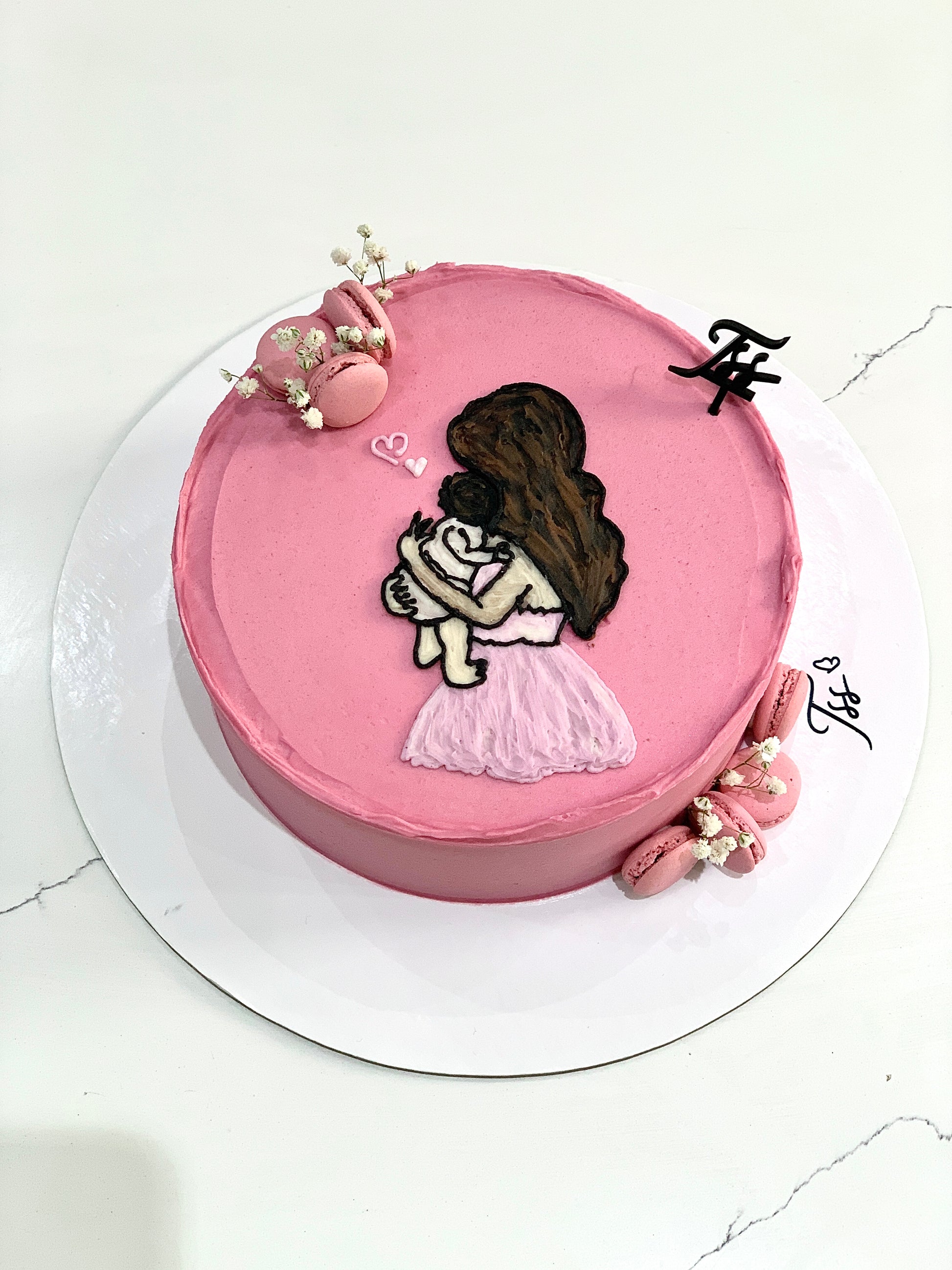 Decorative Mother's Day cake from The Sinful Spoon with floral frosting and colorful accents, perfect for celebrating moms.