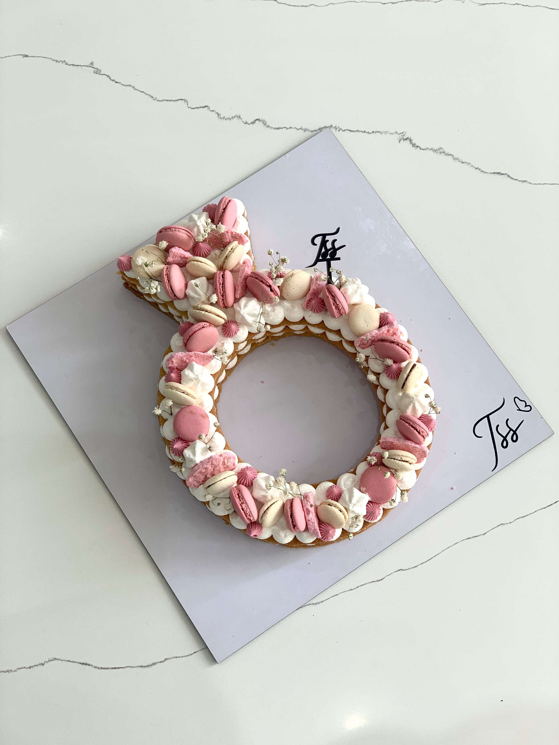 Valentine's Day cake from The Sinful Spoon featuring pink frosting, heart-shaped decorations, and festive romantic design.