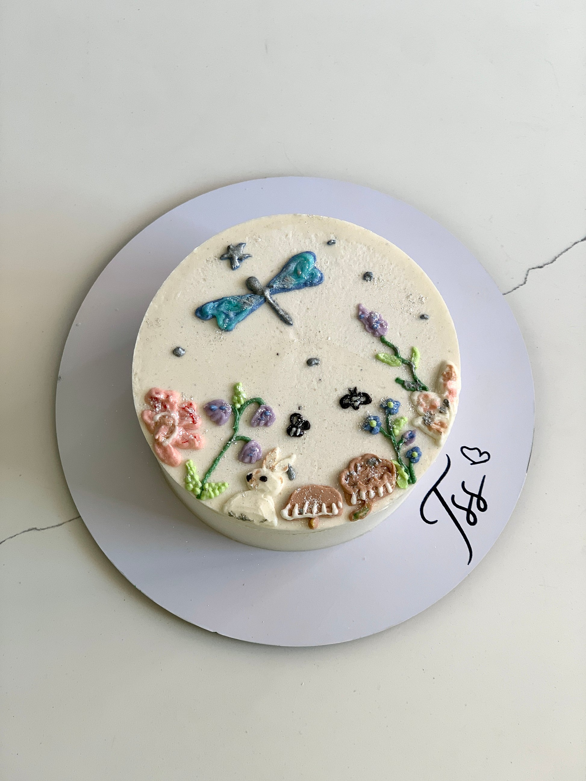Decorative buttercream illustration cake by The Sinful Spoon with colorful floral and artistic piping details.