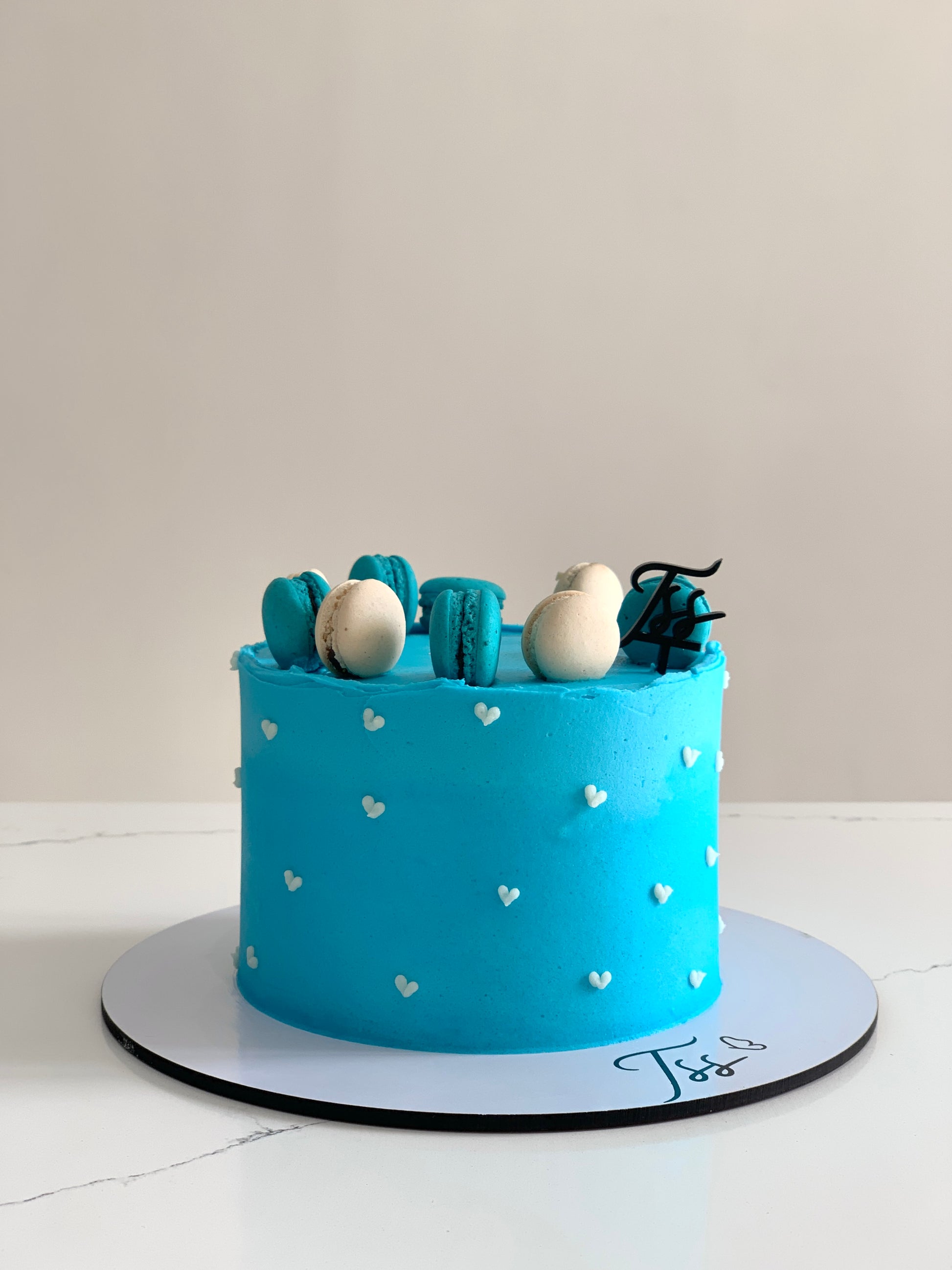 Slice of classic cakes from The Sinful Spoon with colorful frosting and decorative toppings on a white plate.
