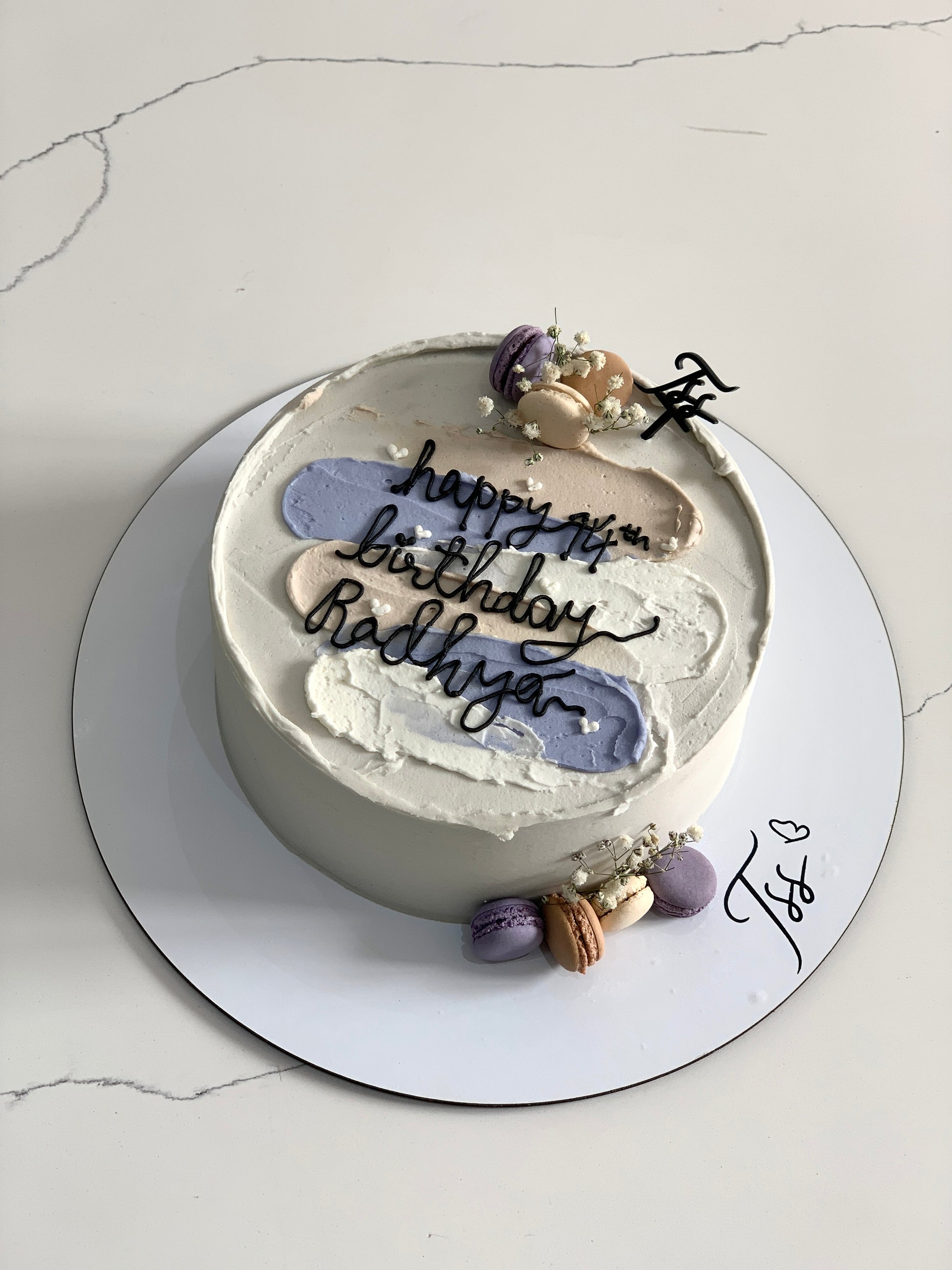 Colorful bento cakes from The Sinful Spoon featuring intricate designs and vibrant icing on a white plate.