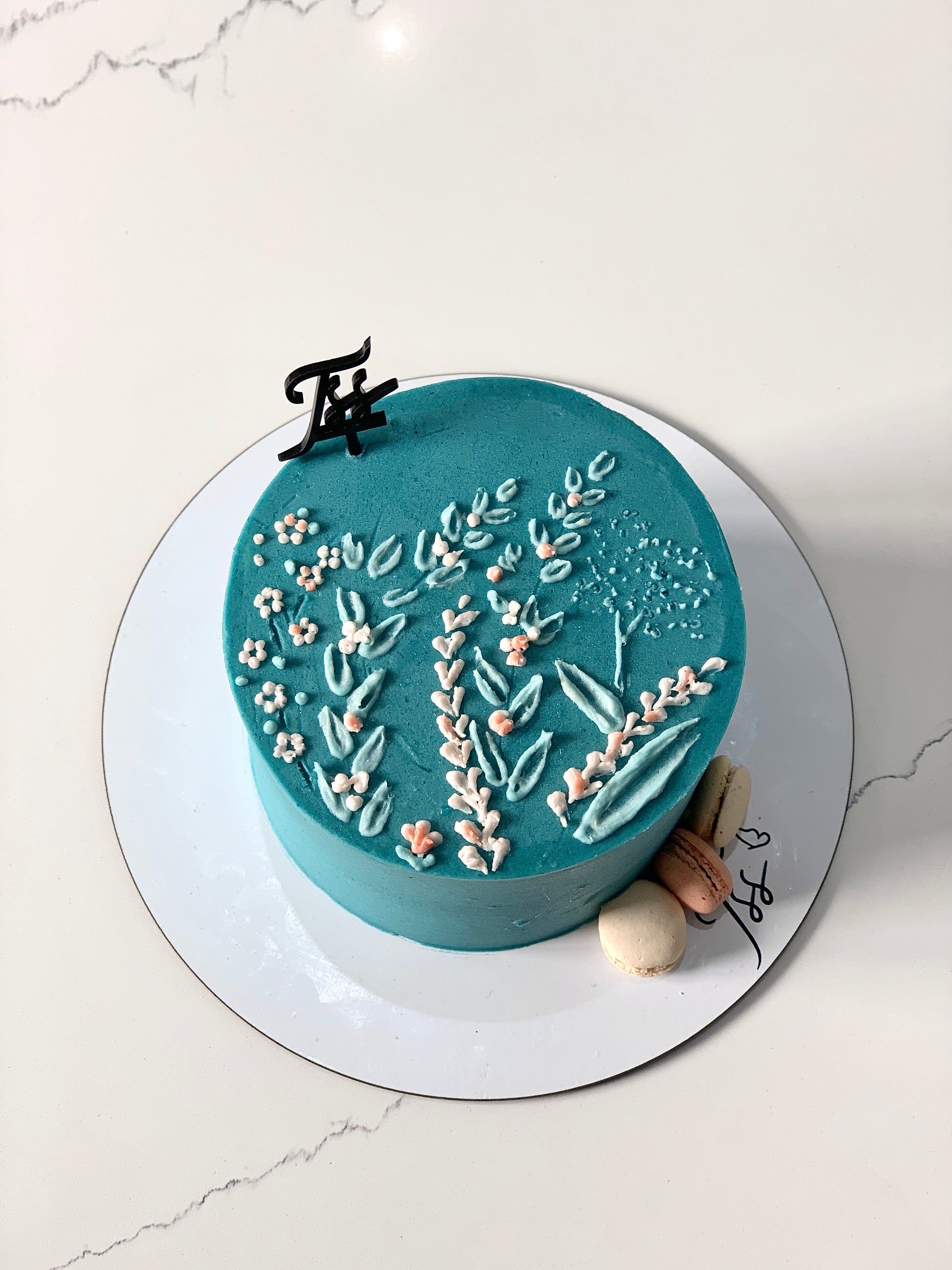 Decorative buttercream flower cake by The Sinful Spoon with intricate floral piping and colorful frosting details.