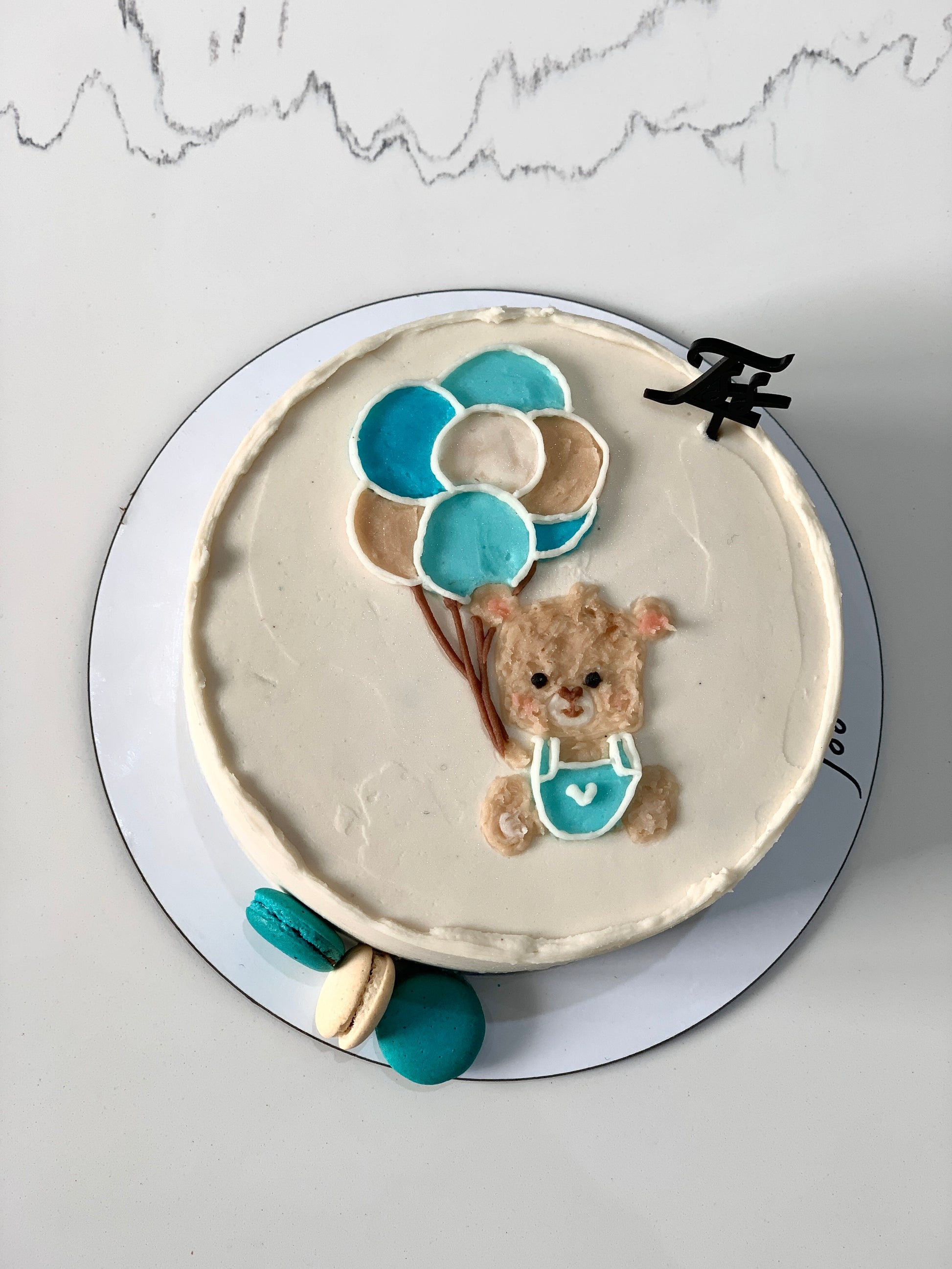 Decorative baby shower cake with pastel icing and adorable baby-themed toppers from The Sinful Spoon.