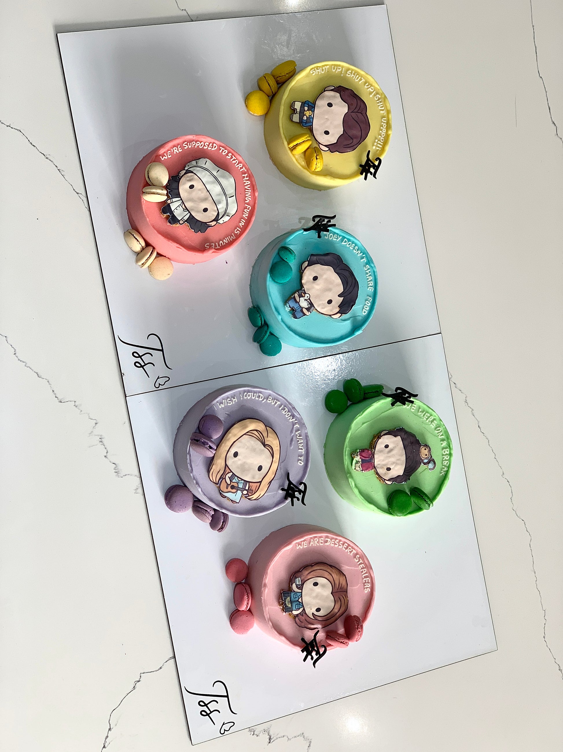 Decorative edible paper cakes by The Sinful Spoon with colorful, intricate designs on top, perfect for special occasions.