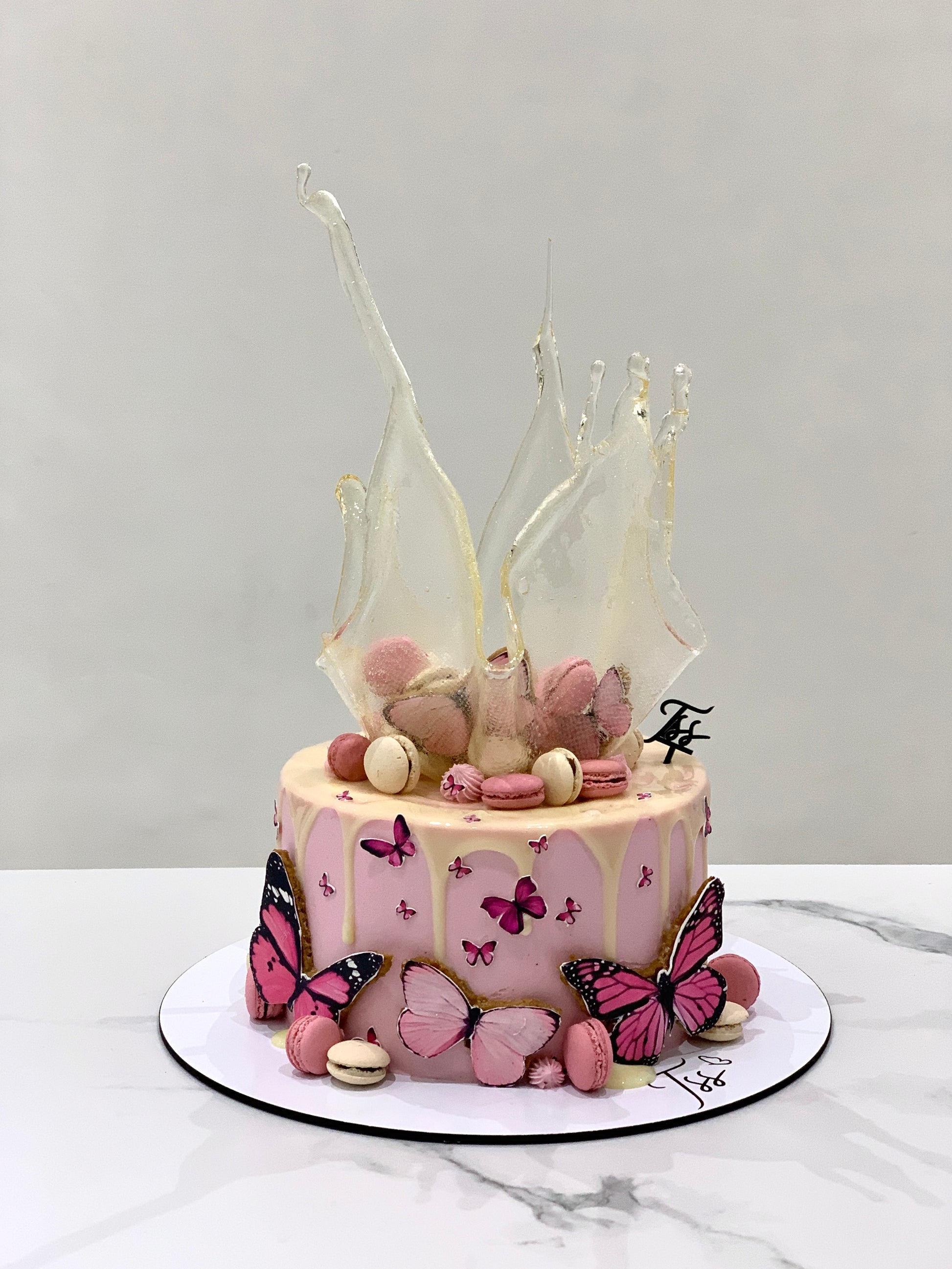 Isomalt cakes from The Sinful Spoon, colorful candy-like sugar art pieces on a white surface.