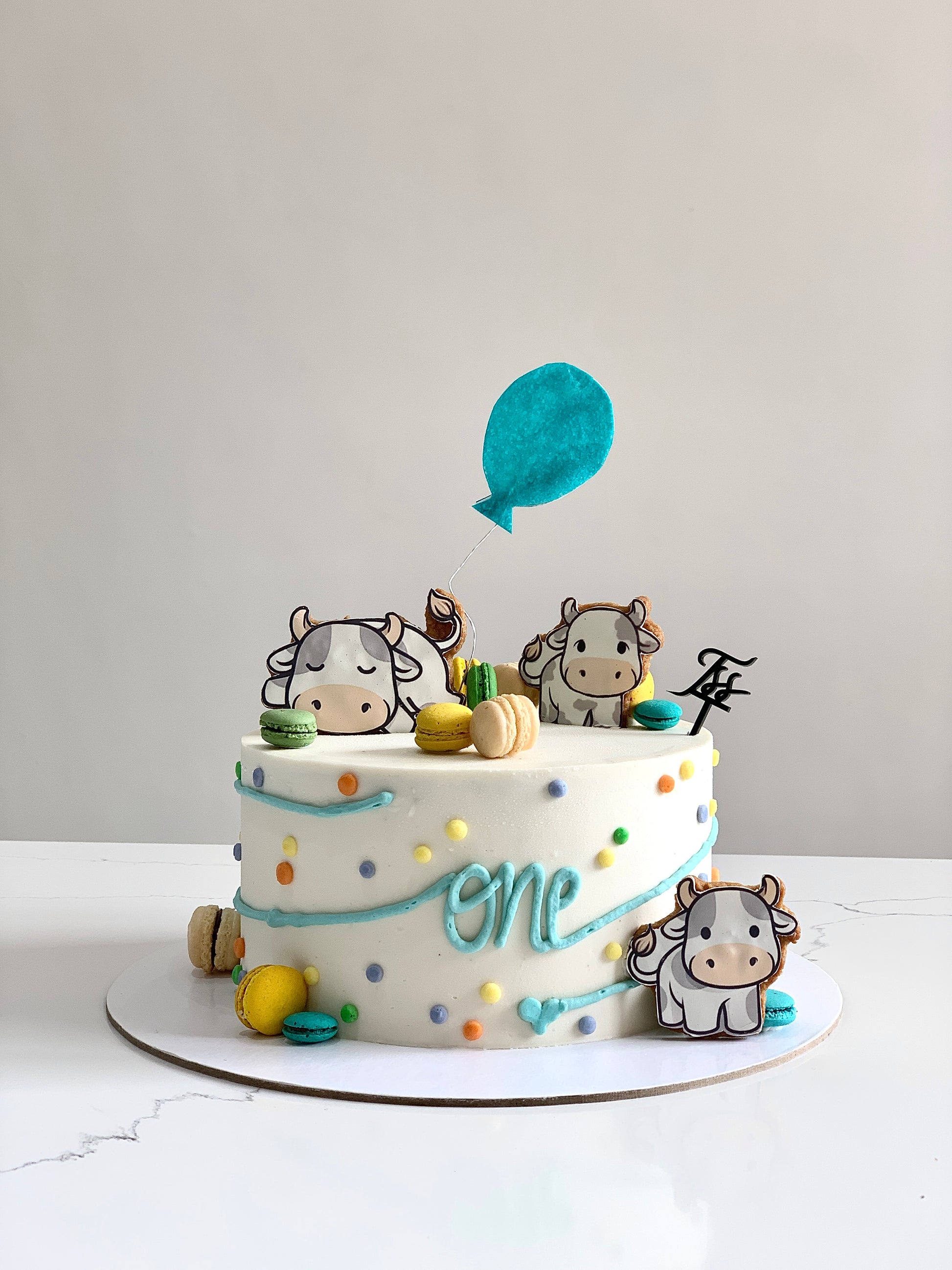 Edible paper cake decorated for a baby boy celebration by The Sinful Spoon, featuring blue and white themed baby shower design.