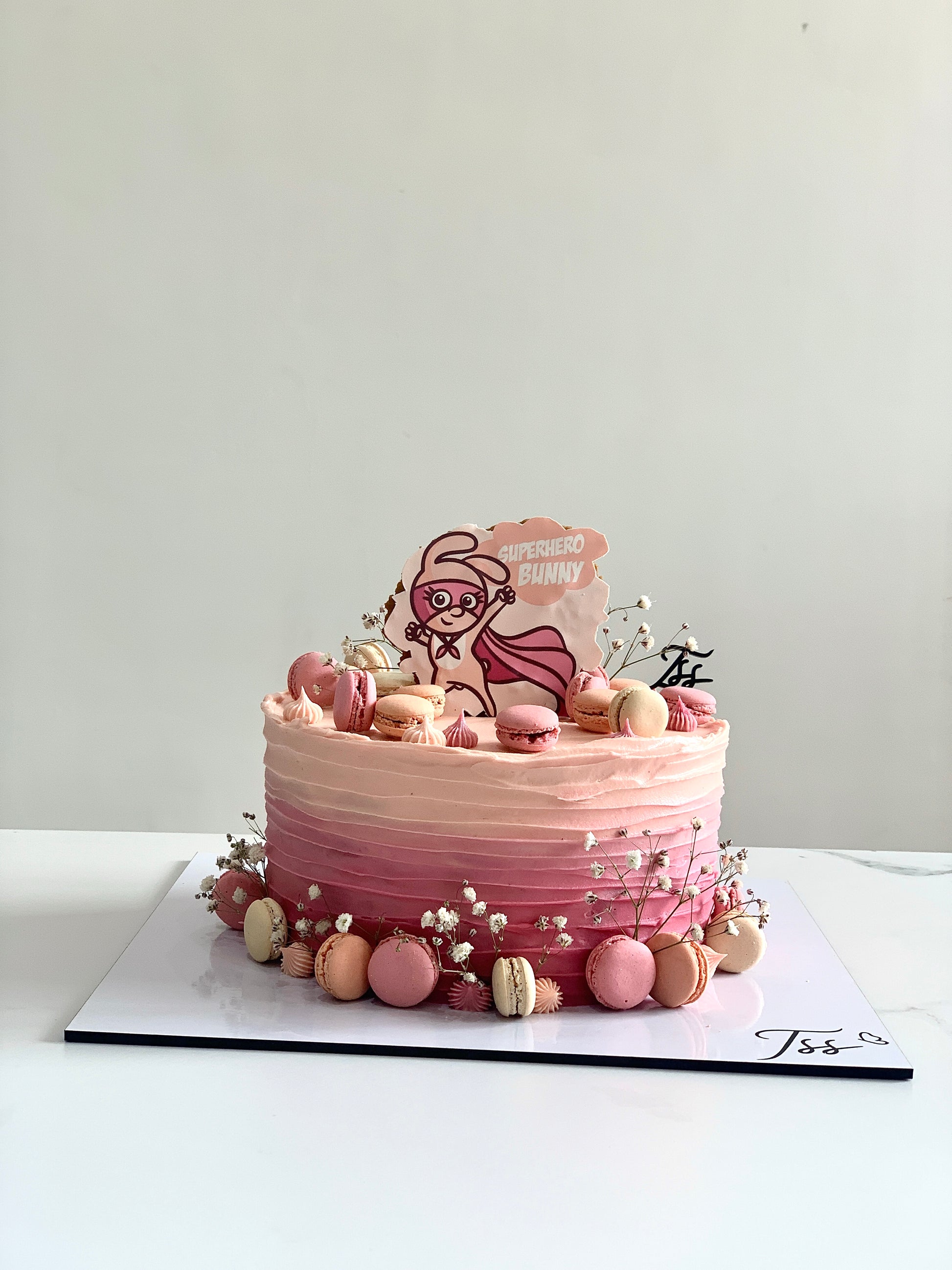Edible paper cake topper for baby girl celebration by The Sinful Spoon, featuring colorful decorative design on a white background.