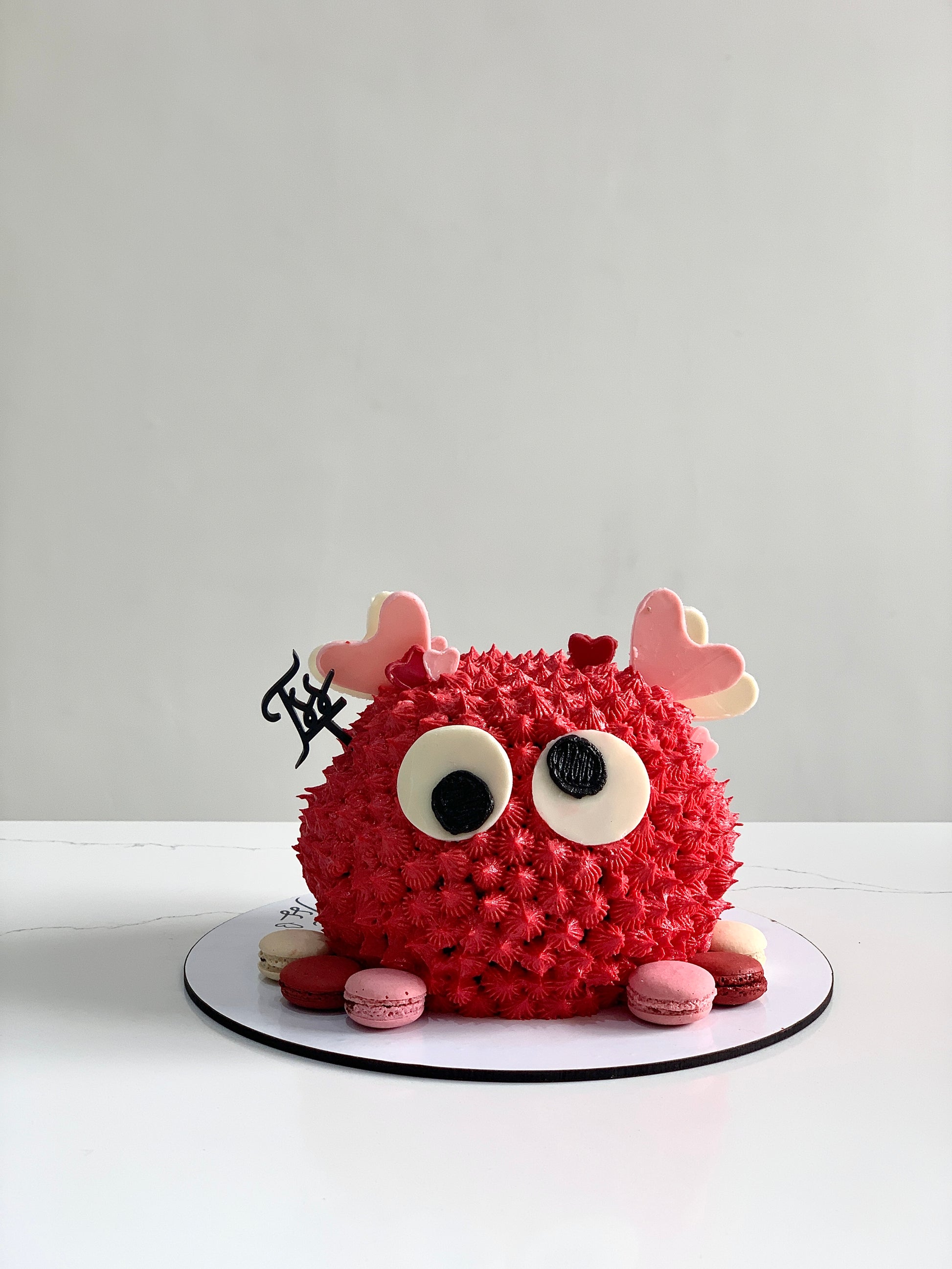 Valentine's Day cake from The Sinful Spoon with pink and red frosting, decorated with hearts and sweet details.