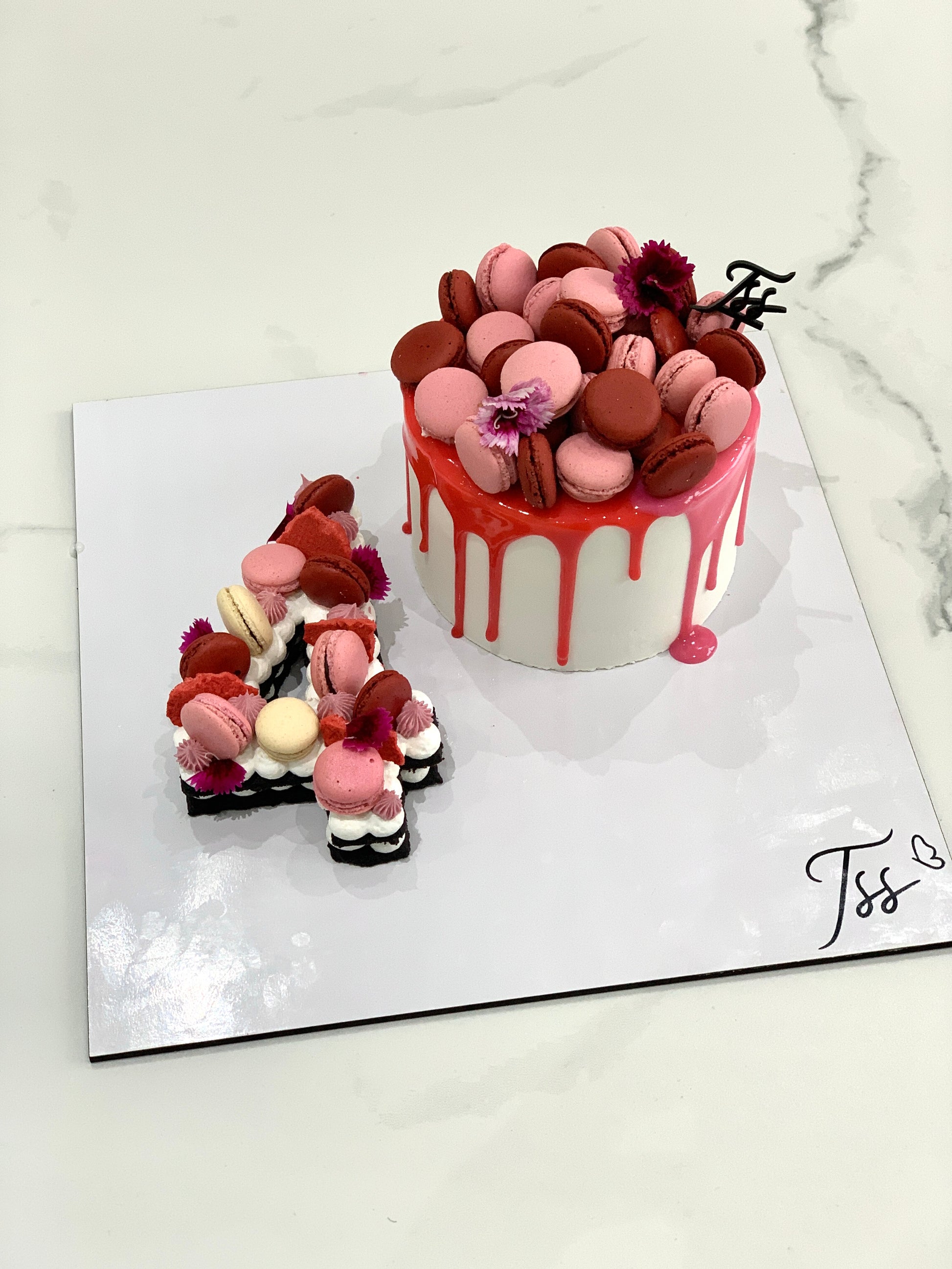 Assorted combo cakes from The Sinful Spoon, featuring layered cakes with colorful frosting and decorative toppings.