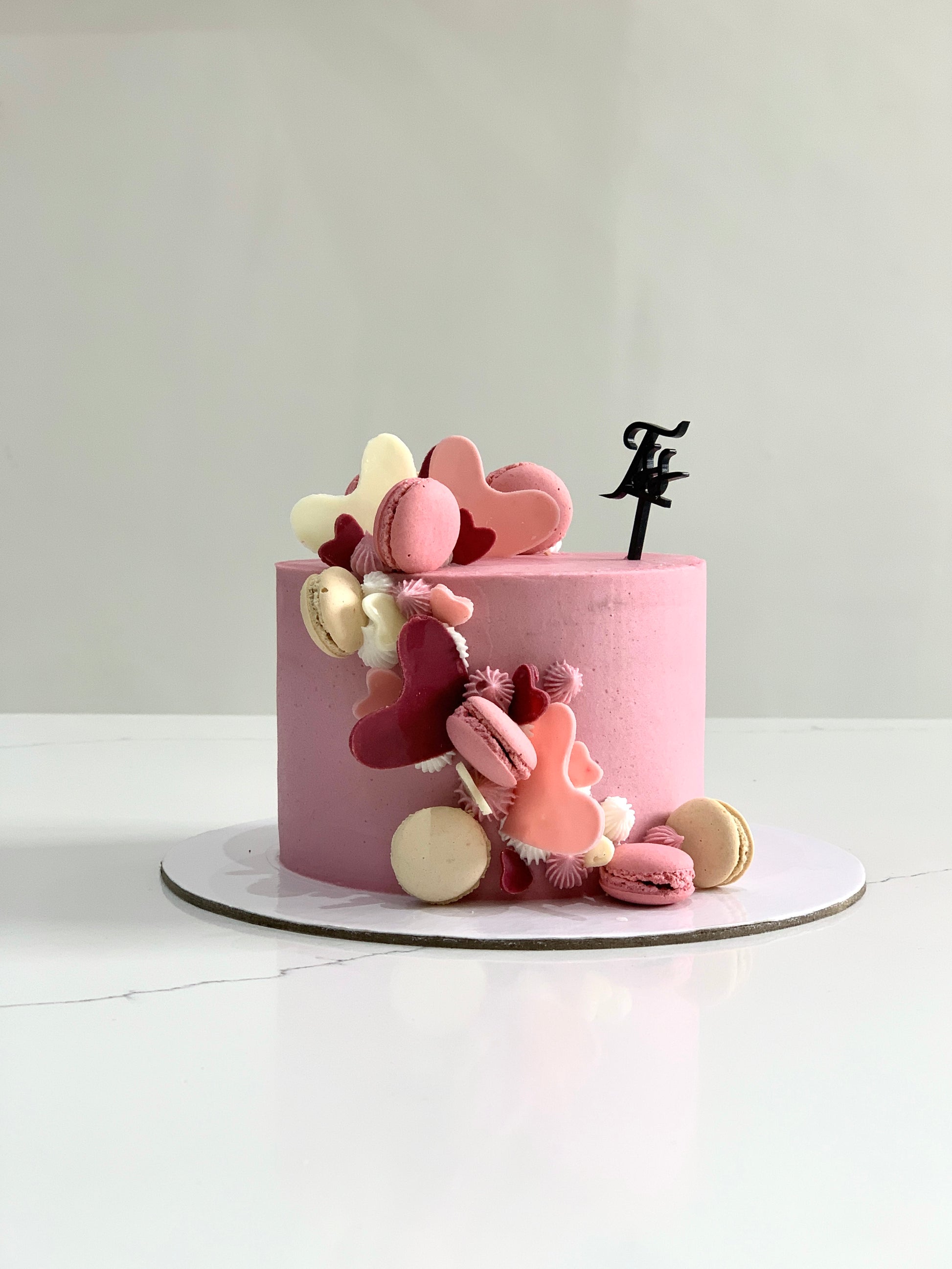 Valentine's Day cake from The Sinful Spoon with pink frosting, heart-shaped decorations, and festive Valentine's Day themed design.