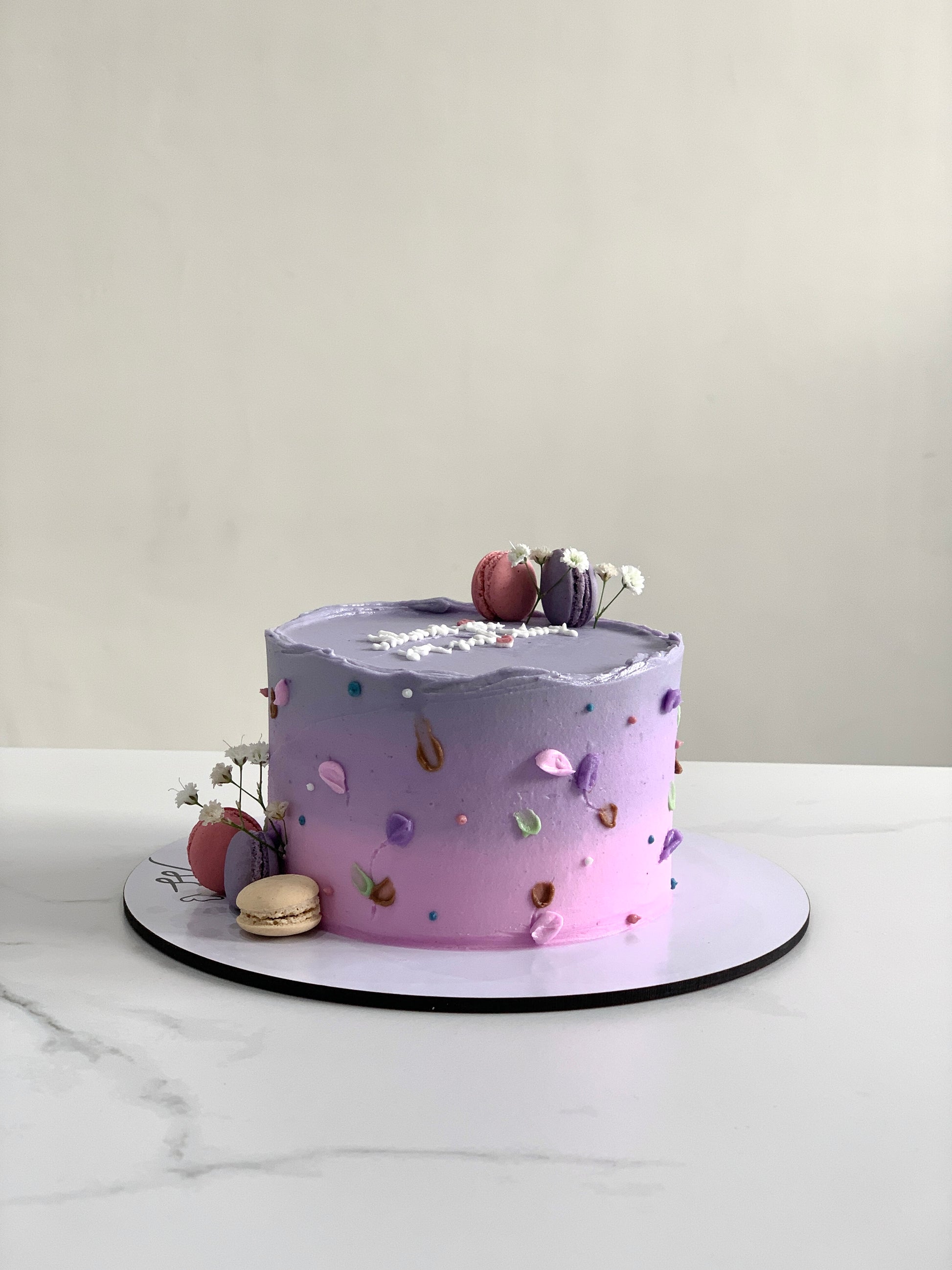 Buttercream flower cake by The Sinful Spoon featuring colorful floral decorations on a tiered cake.