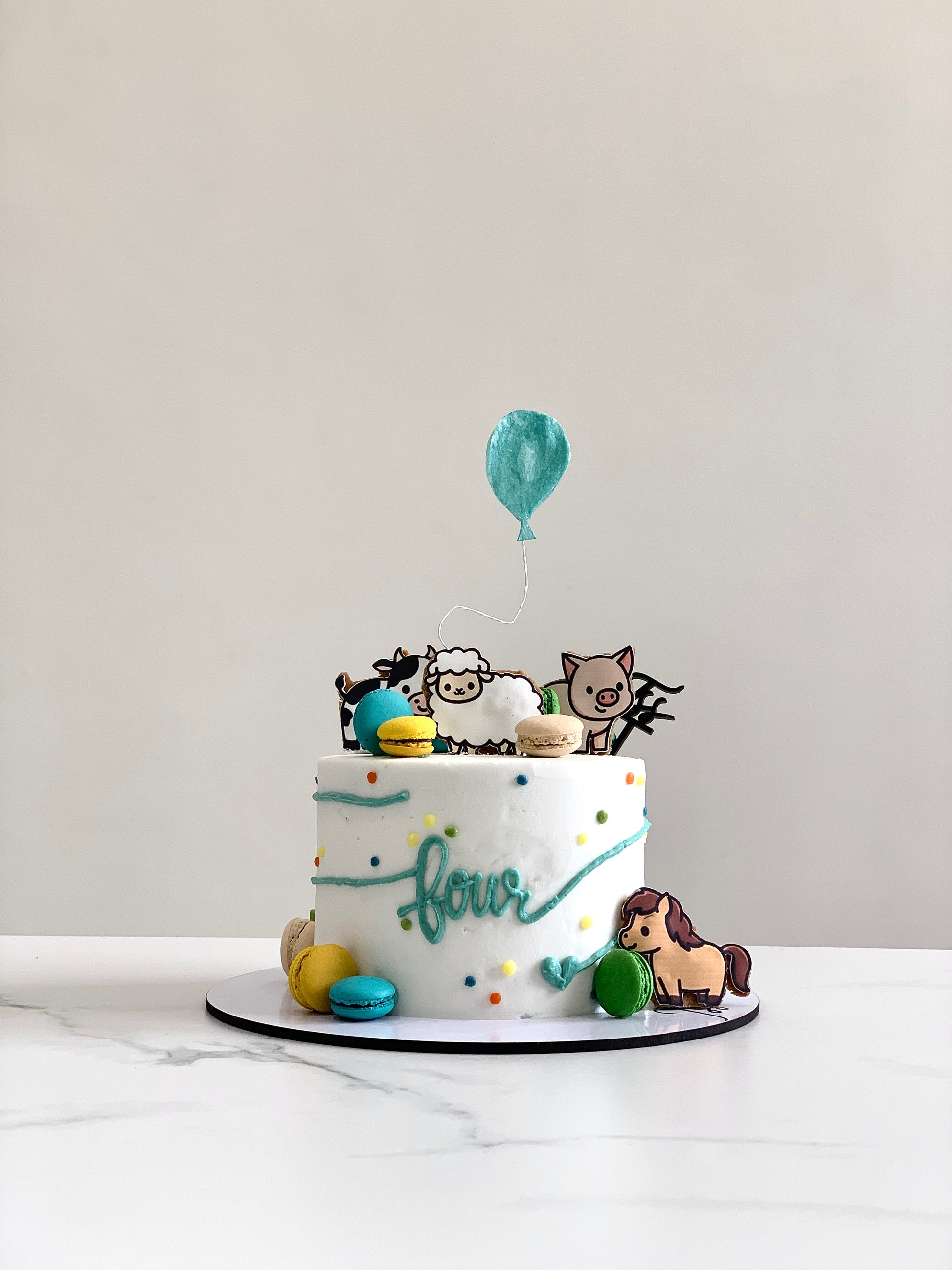 Edible paper cake with baby boy design by The Sinful Spoon, featuring colorful, detailed decorative cake art for celebration.