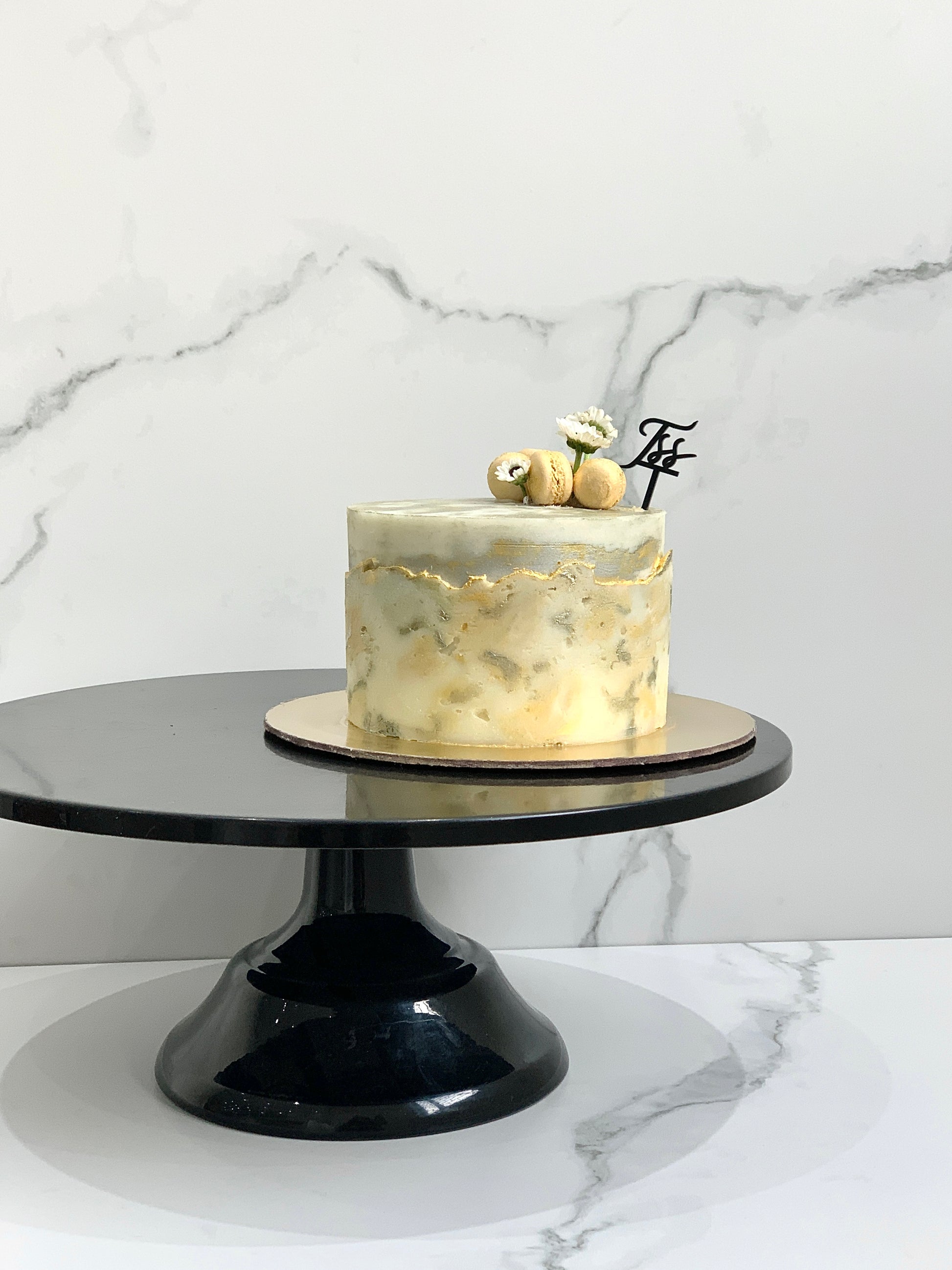 Classic cakes from The Sinful Spoon featuring layered frosting and decorative toppings on a white plate.