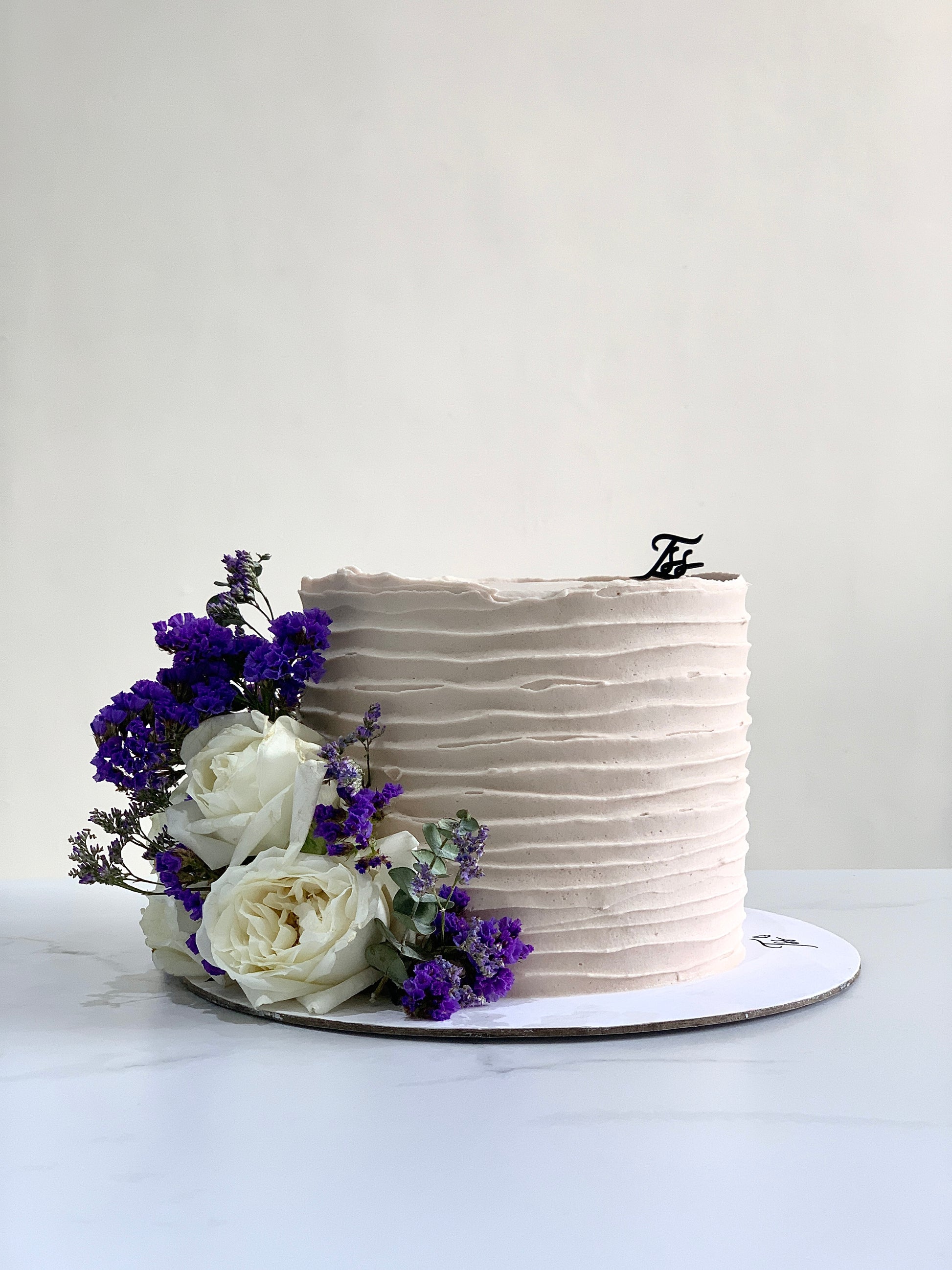 Fresh floral cakes from The Sinful Spoon, decorated with colorful edible flowers and intricate frosting designs.