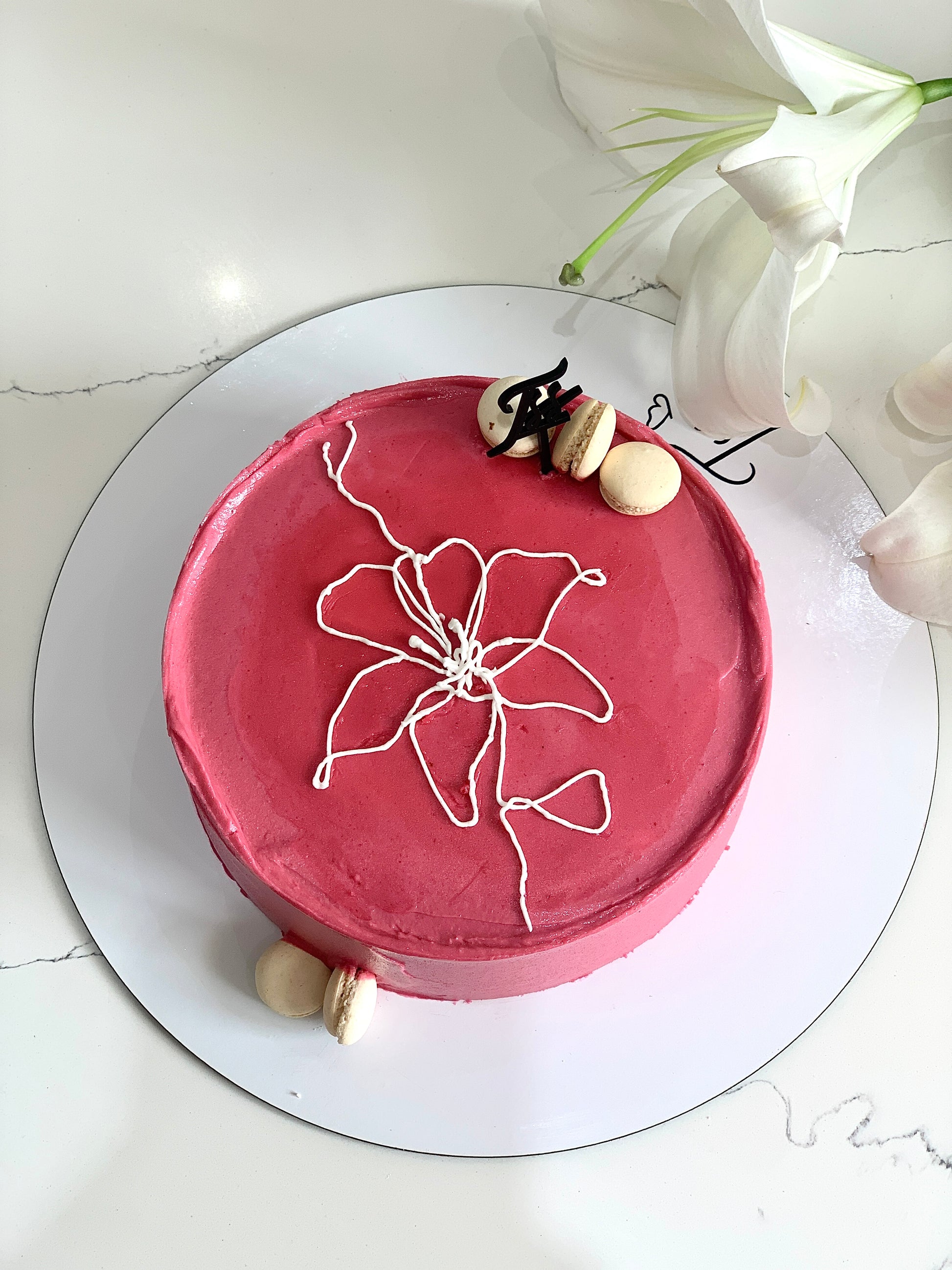 Decorative Mother's Day cake from The Sinful Spoon featuring floral frosting and festive design on a white platter.