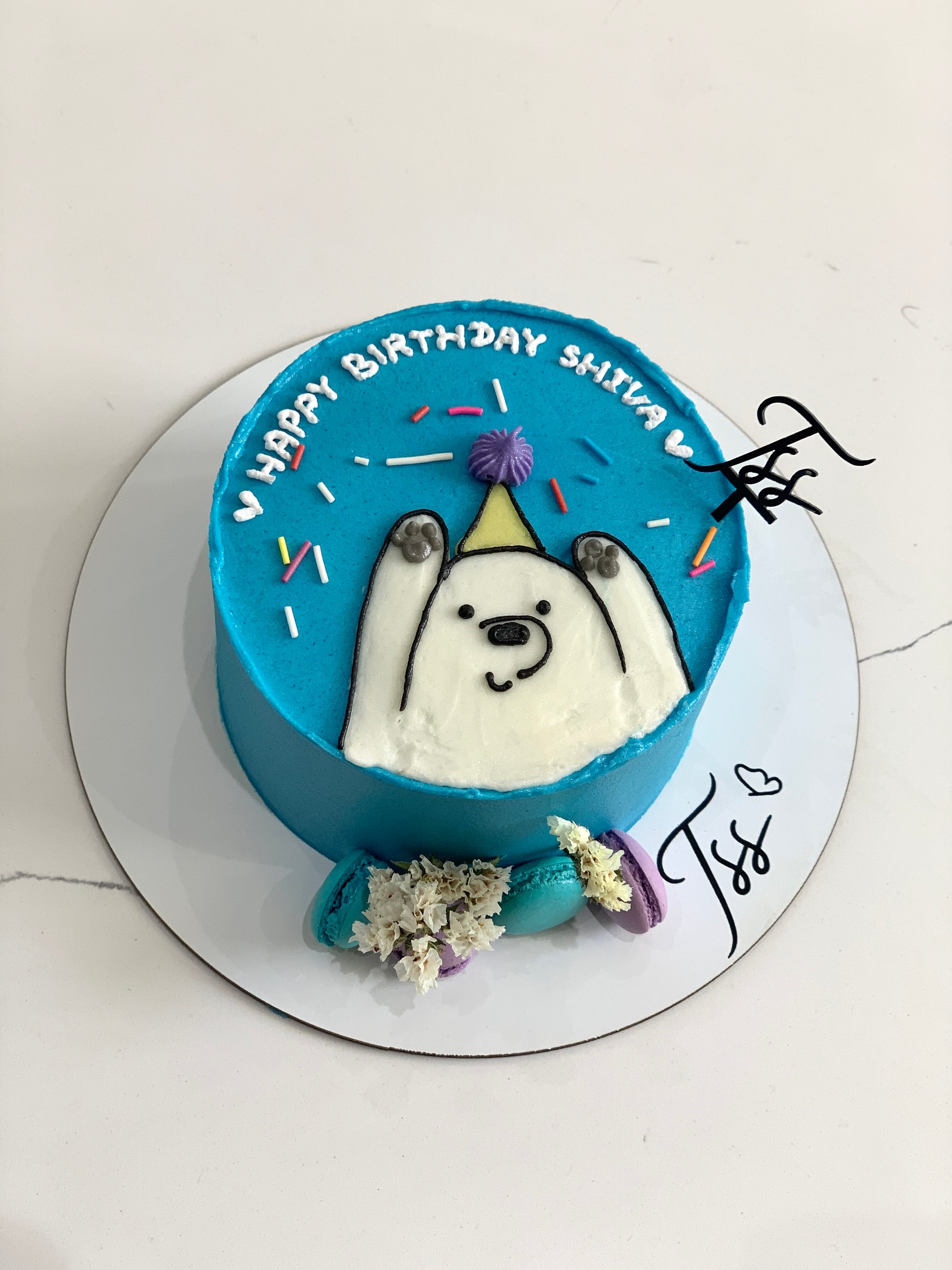 Decorative buttercream illustration cake by The Sinful Spoon, featuring colorful floral and whimsical designs on a layered cake.