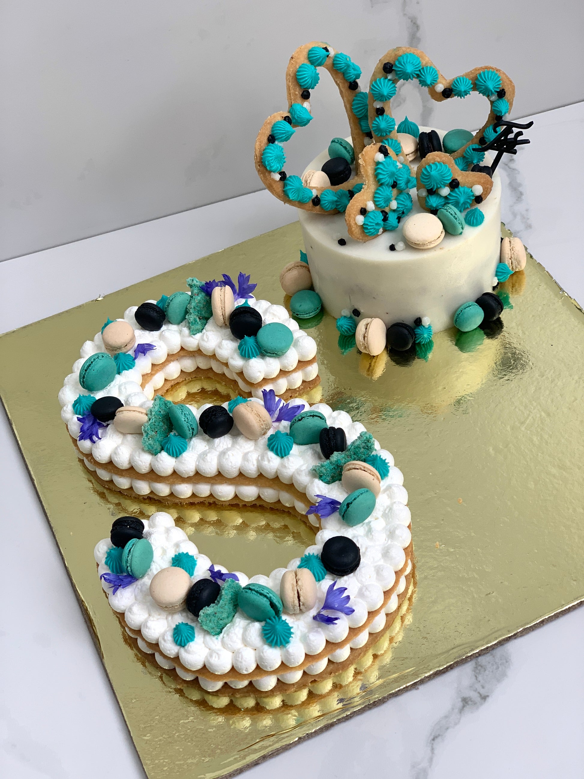 Assorted combo cakes from The Sinful Spoon with colorful frosting and decorative toppings on a white plate.