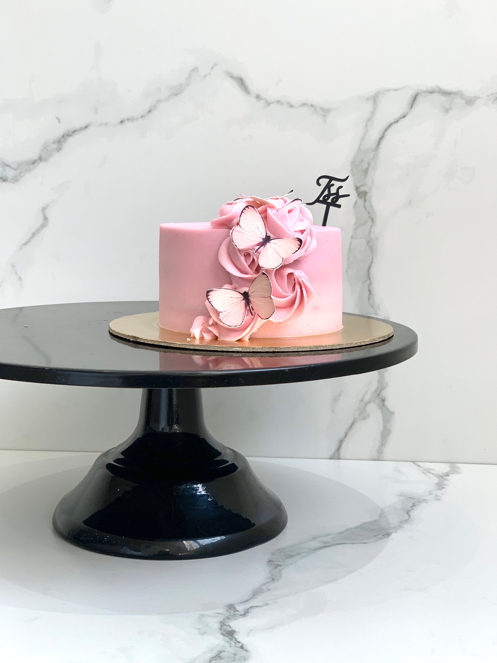 Edible paper cake for baby girl by The Sinful Spoon with pink and white decorations, perfect for baby showers and celebrations.