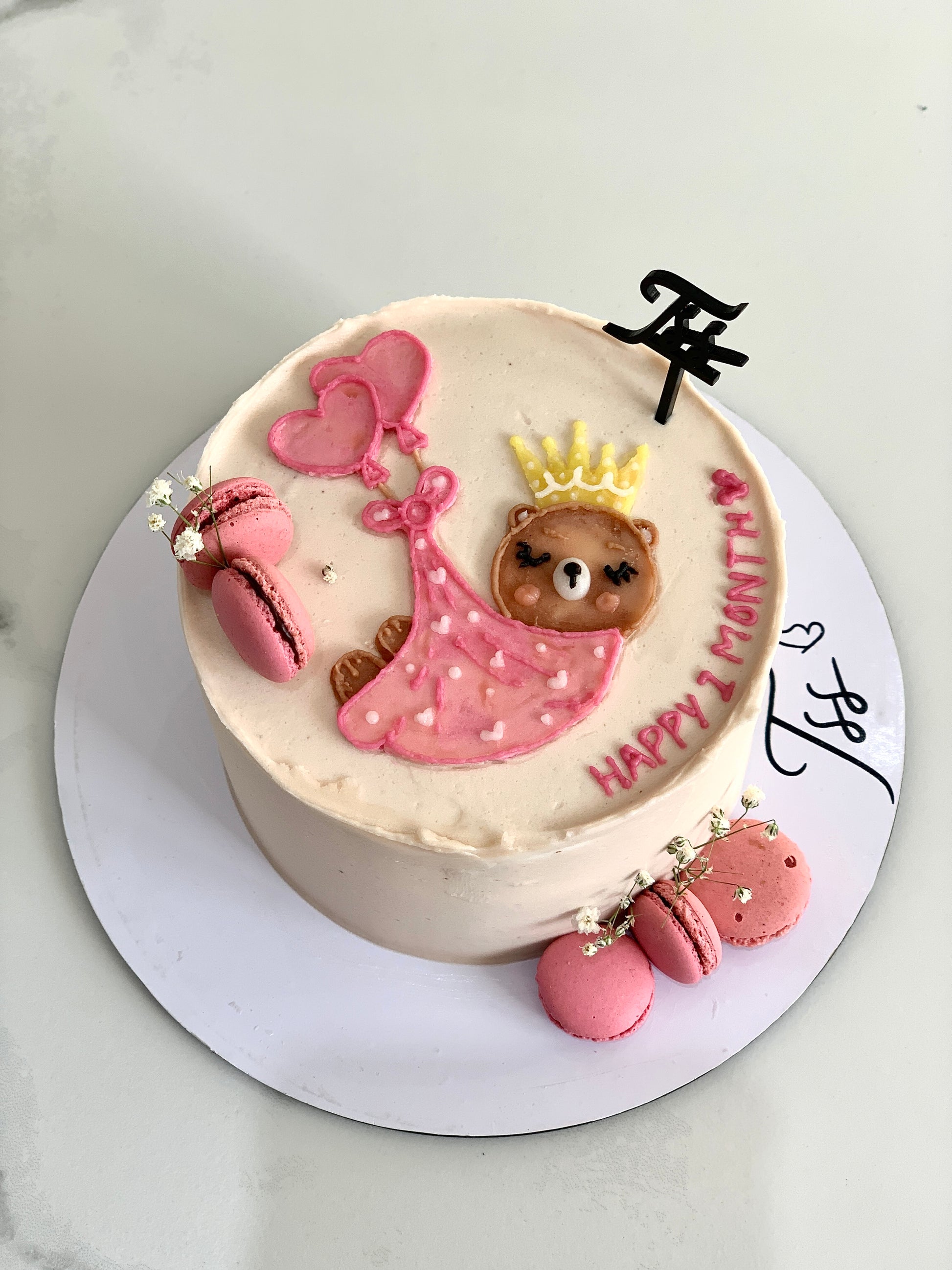 Decorative baby shower cake with pastel frosting and adorable baby-themed decorations from The Sinful Spoon.