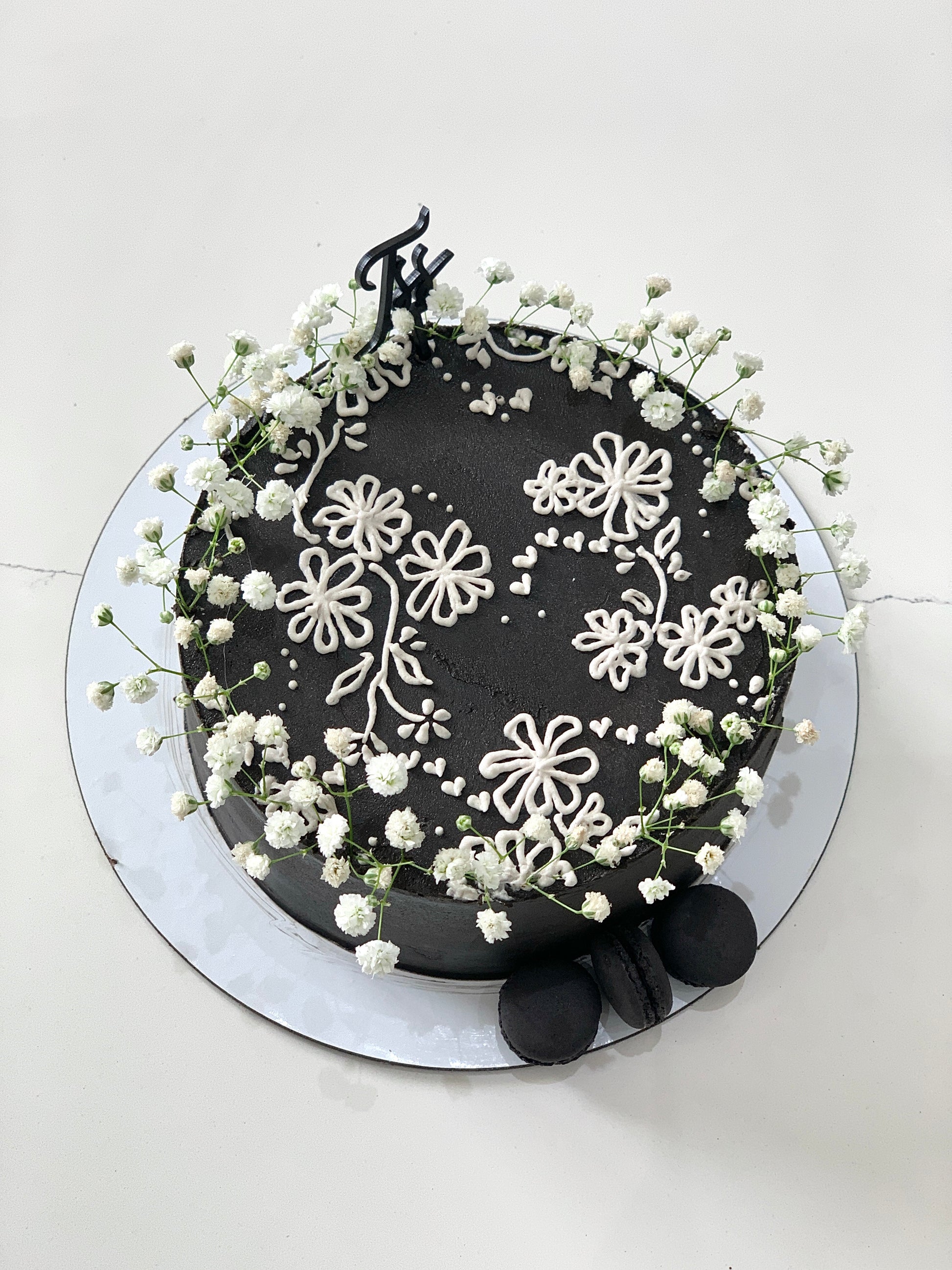 Decorative buttercream flower cake by The Sinful Spoon with colorful floral designs on a tiered cake.