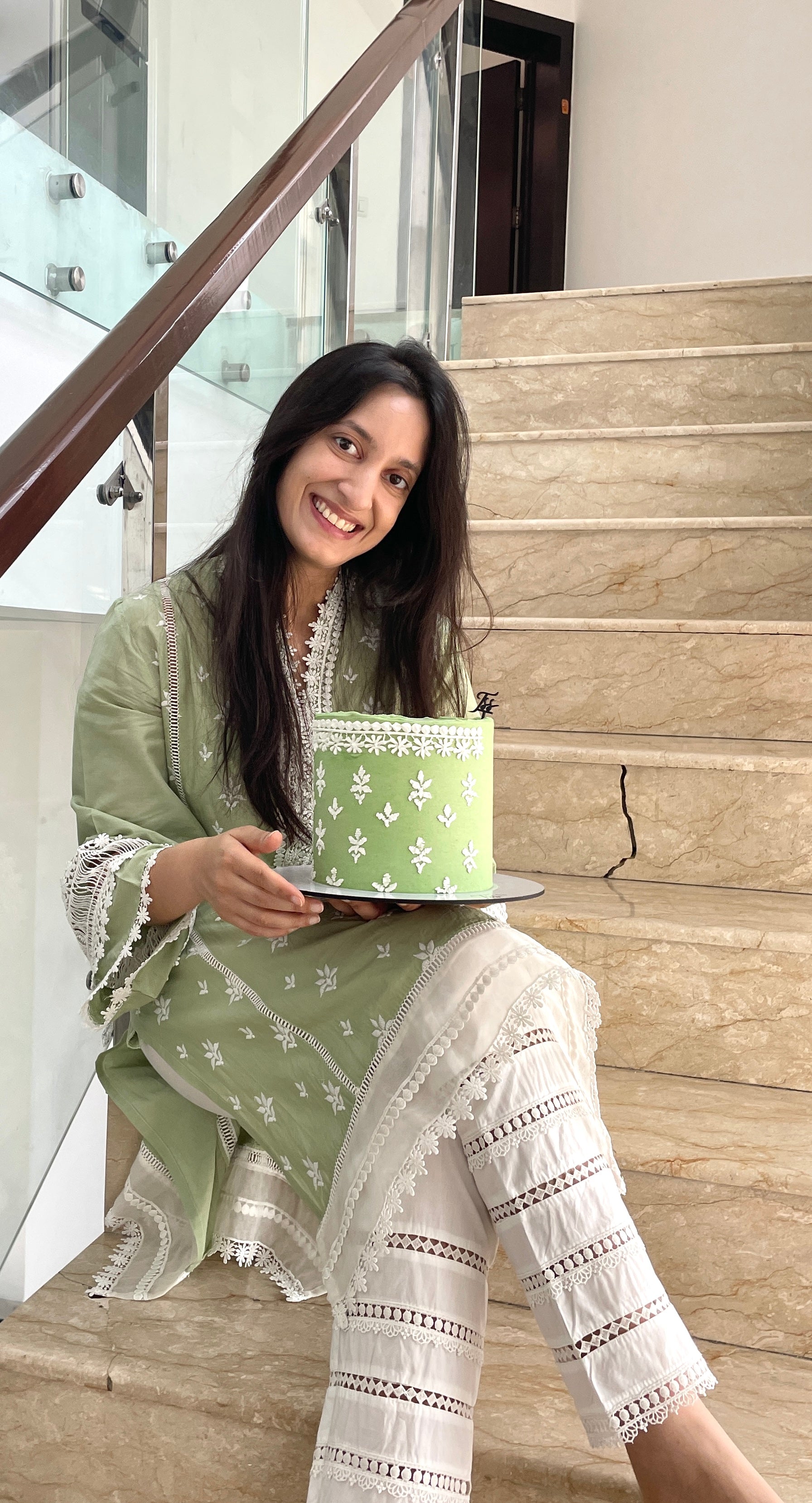 Decorative fashion-themed cake from The Sinful Spoon featuring colorful icing and intricate design on a white background.