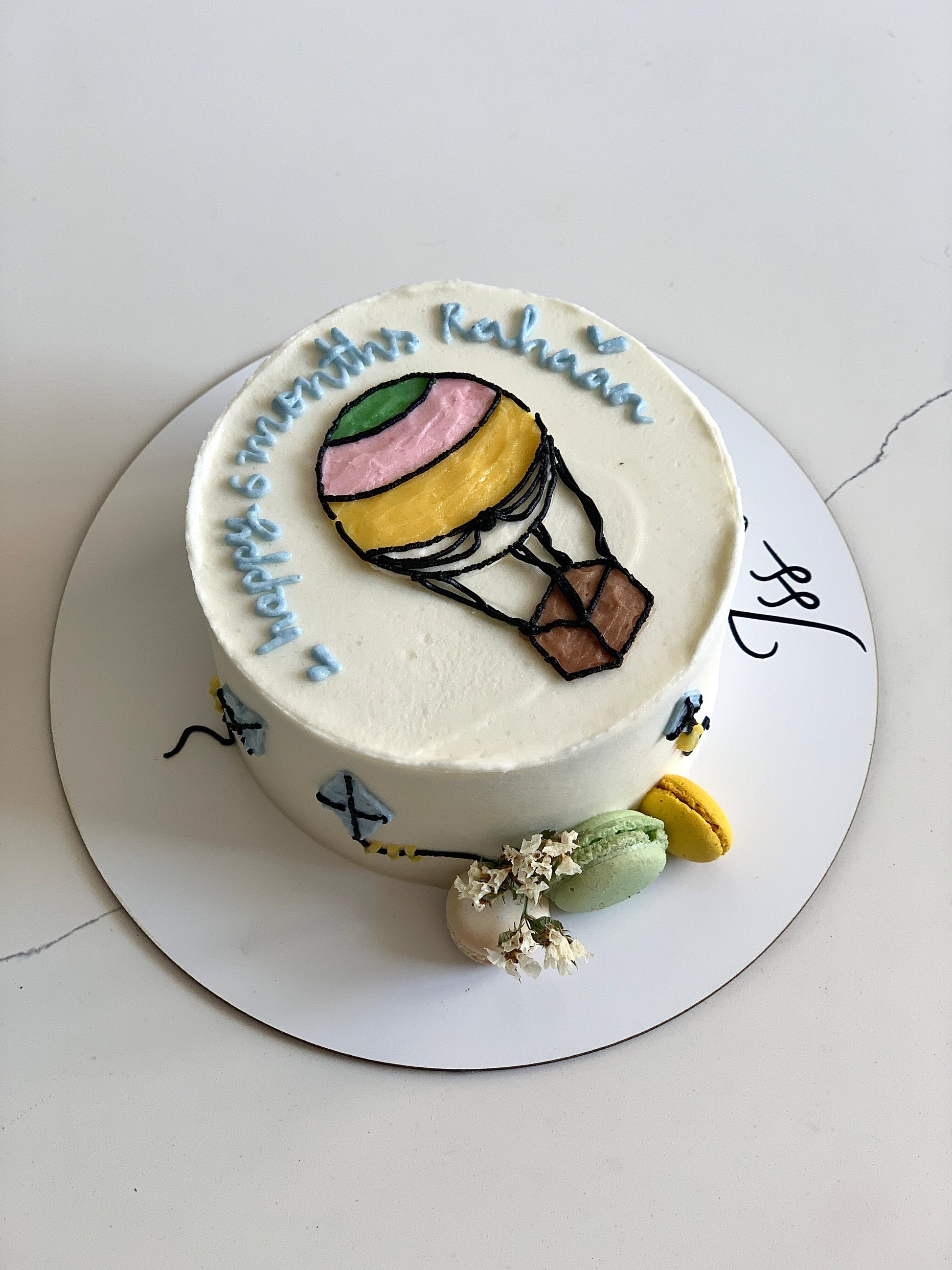 Buttercream illustration cake by The Sinful Spoon with colorful floral and whimsical designs on a layered cake.